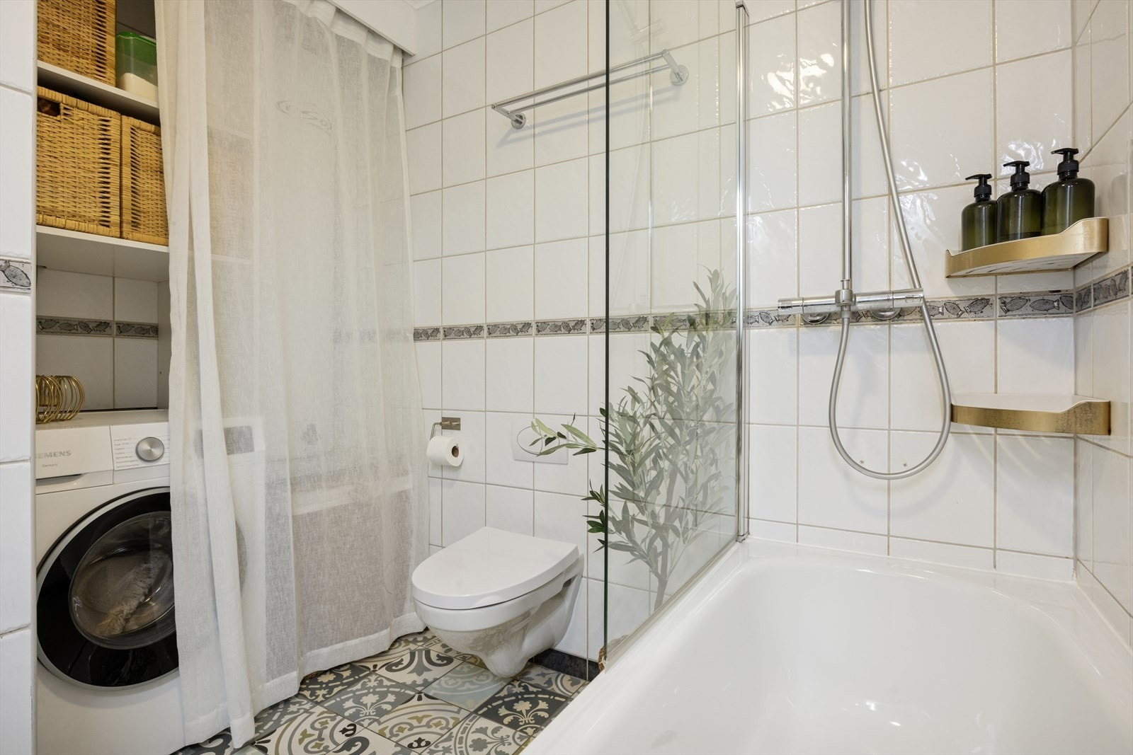 Flis på gulv og vegger. Innehar: badekar med dusjgarnityr på vegg, innredning med servant, vegghengt toalett og varmtvannsbereder. Galleribilde