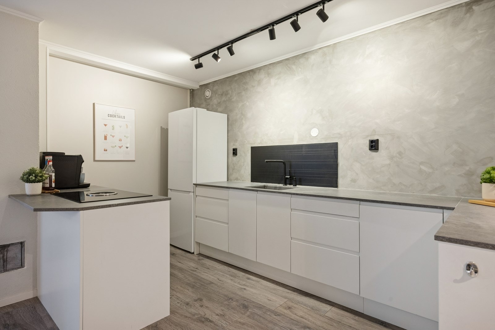 Innredning med folierte skrog og slette fronter. Benkeplate av stein. Integrerte hvitevarer: Oppvaskmaskin, platetopp og stekeovn. Galleribilde