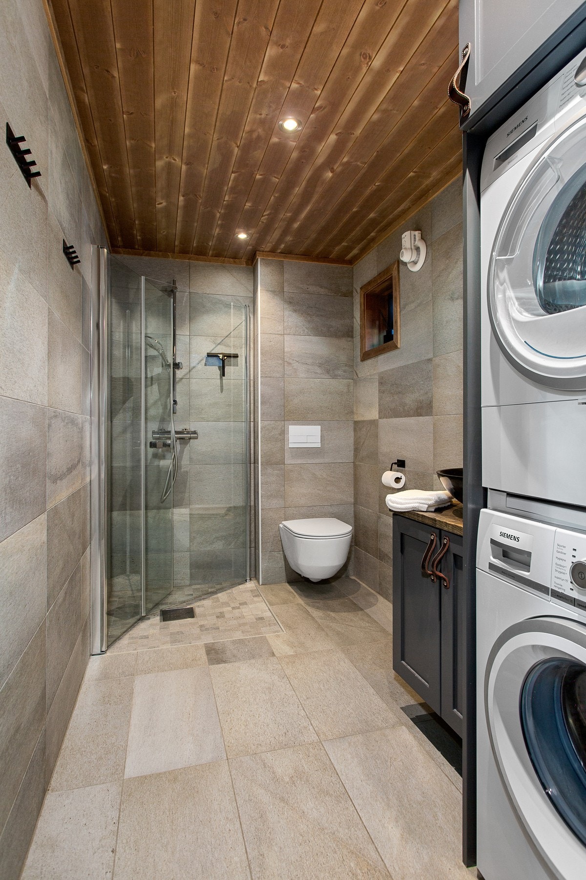 heltre baderomsinnredning og skap for vaskemaskin og tørketrommel bygd av Bakkens Treprodukter fra Vinstra. Gulvvarme Galleribilde