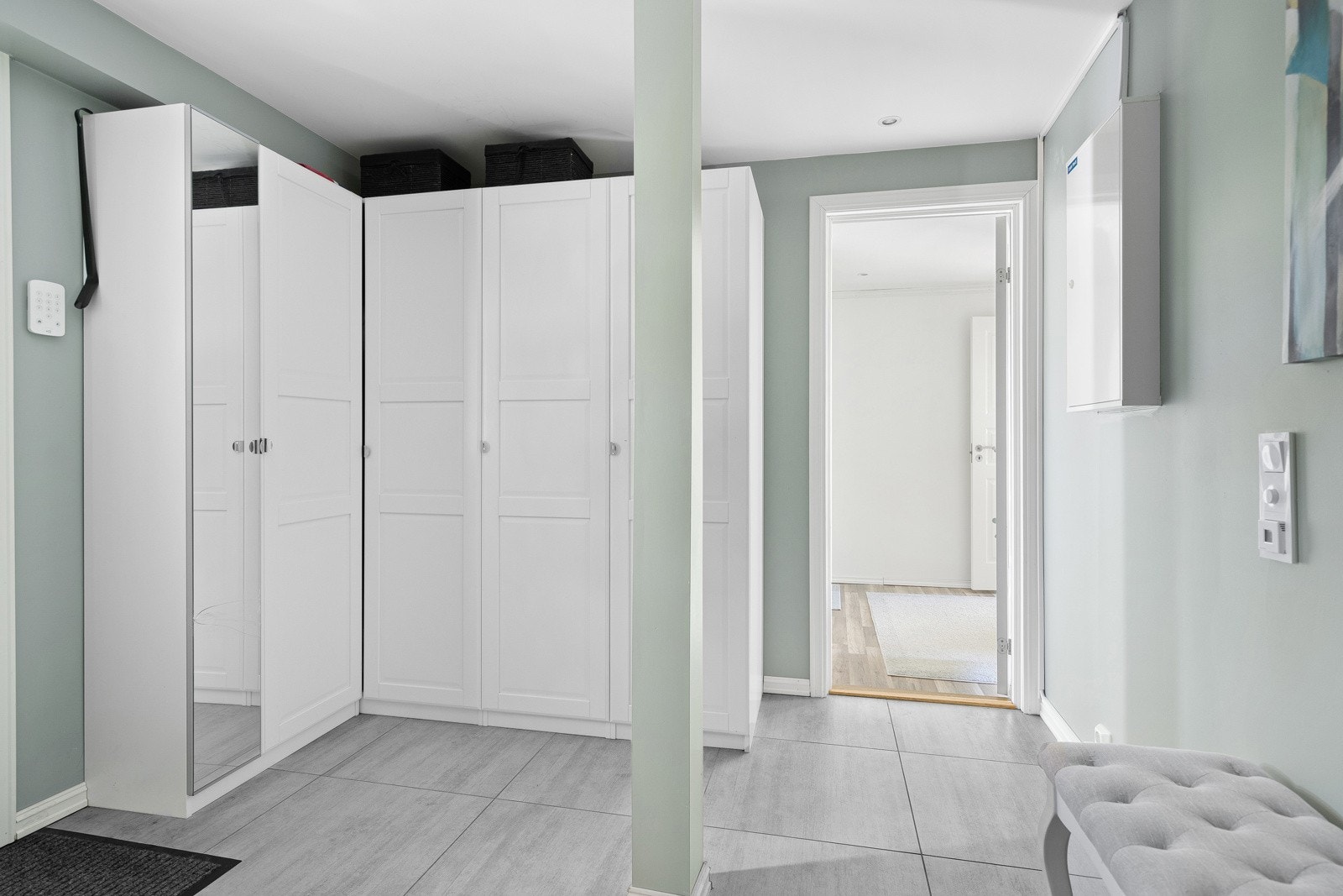 De lyse veggene og et vindu som slipper inn naturlig lys gir rommet en åpen og innbydende følelse. Her er det godt med plass til oppbevaring av yttertøy og sko, og garderobeskap sørger for orden i hverdagen. Galleribilde