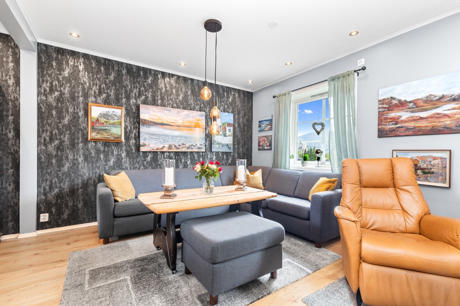 Veggen bak sofaen er tapetsert, taket er foroet ned og her er det montert down-lights Galleribilde