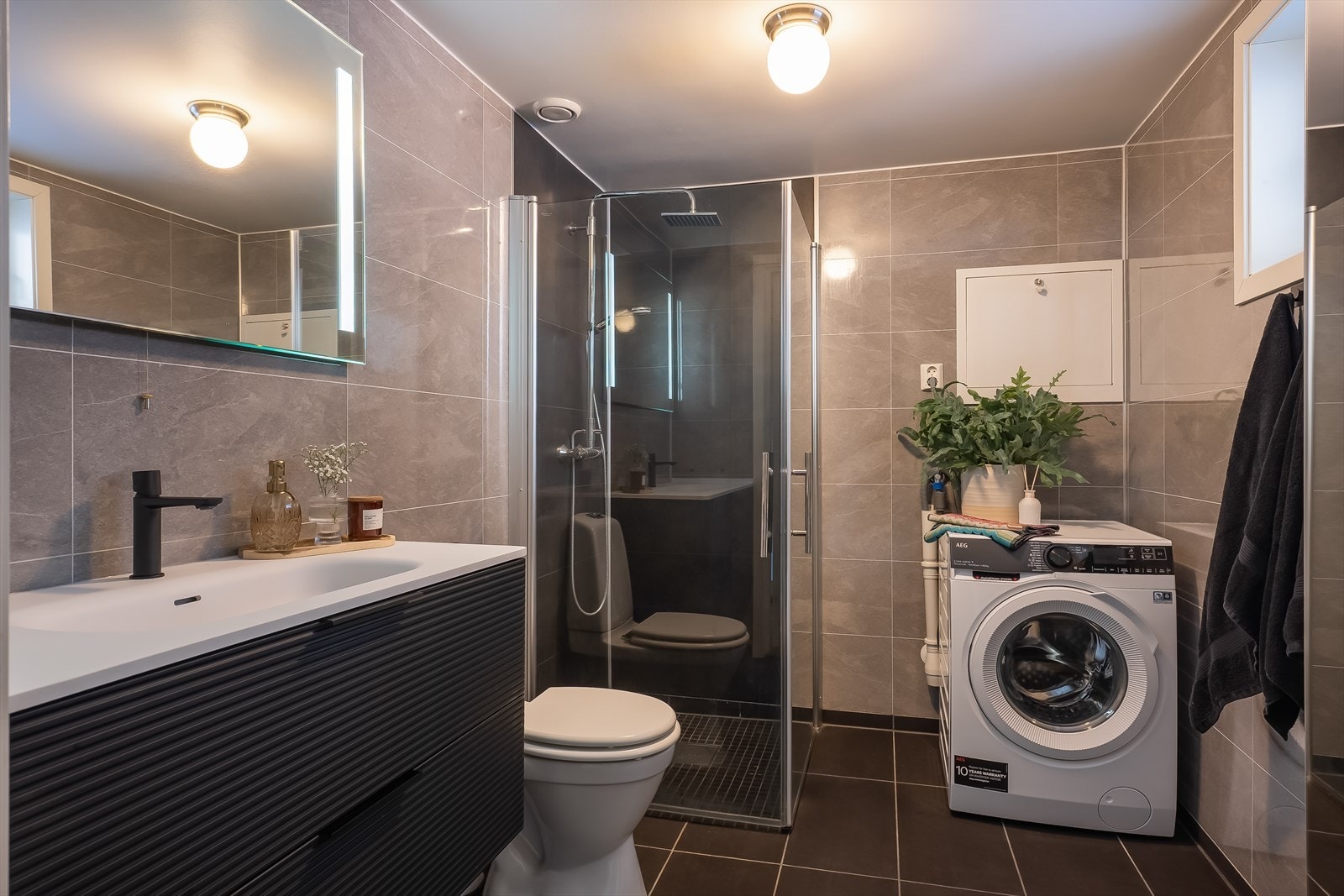 Baderommet innehar behagelig gulvvarme, dusjhjørne med dusjgarnityr på vegg, samt ferdig opplegg for vaskemaskin. Galleribilde