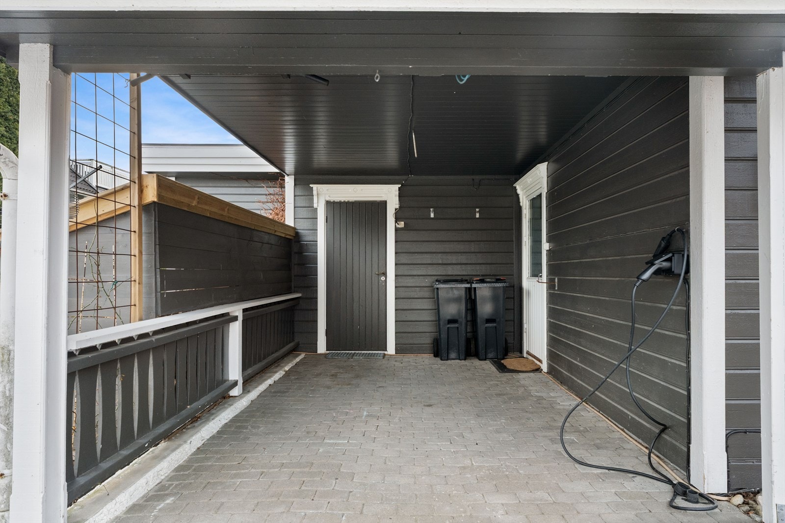 Overbygd carport med elbillader og direkte inngang til bod. Galleribilde