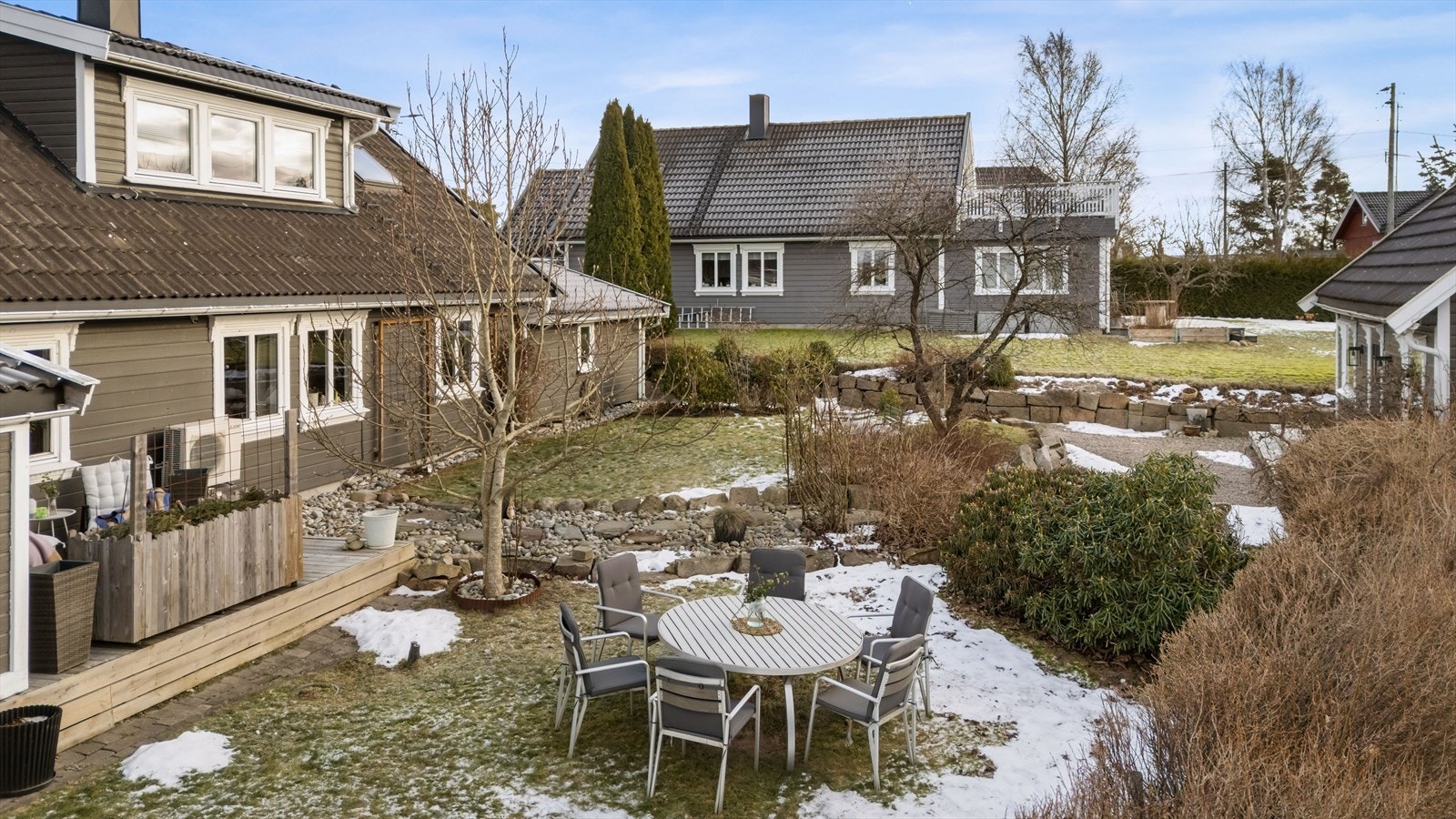 Stor og opparbeidet hage med plen, busker og flere sitteplasser. Galleribilde