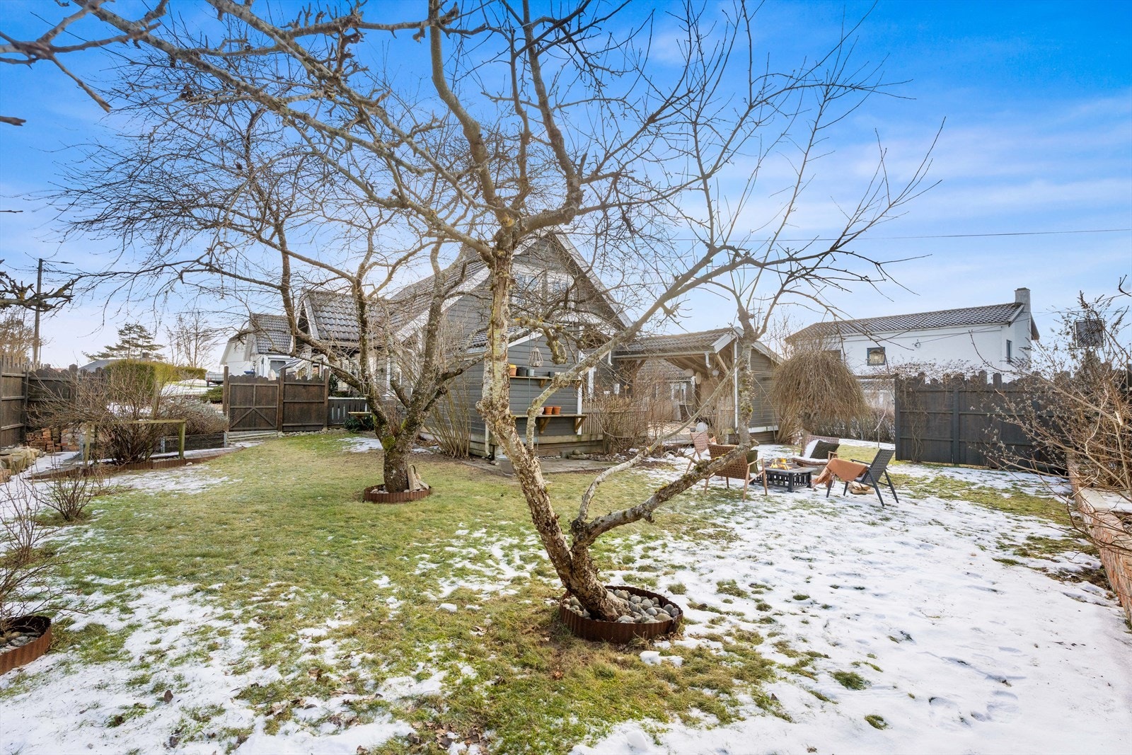 Epletrær og annen beplantning skaper en frodig og privat hage. Galleribilde