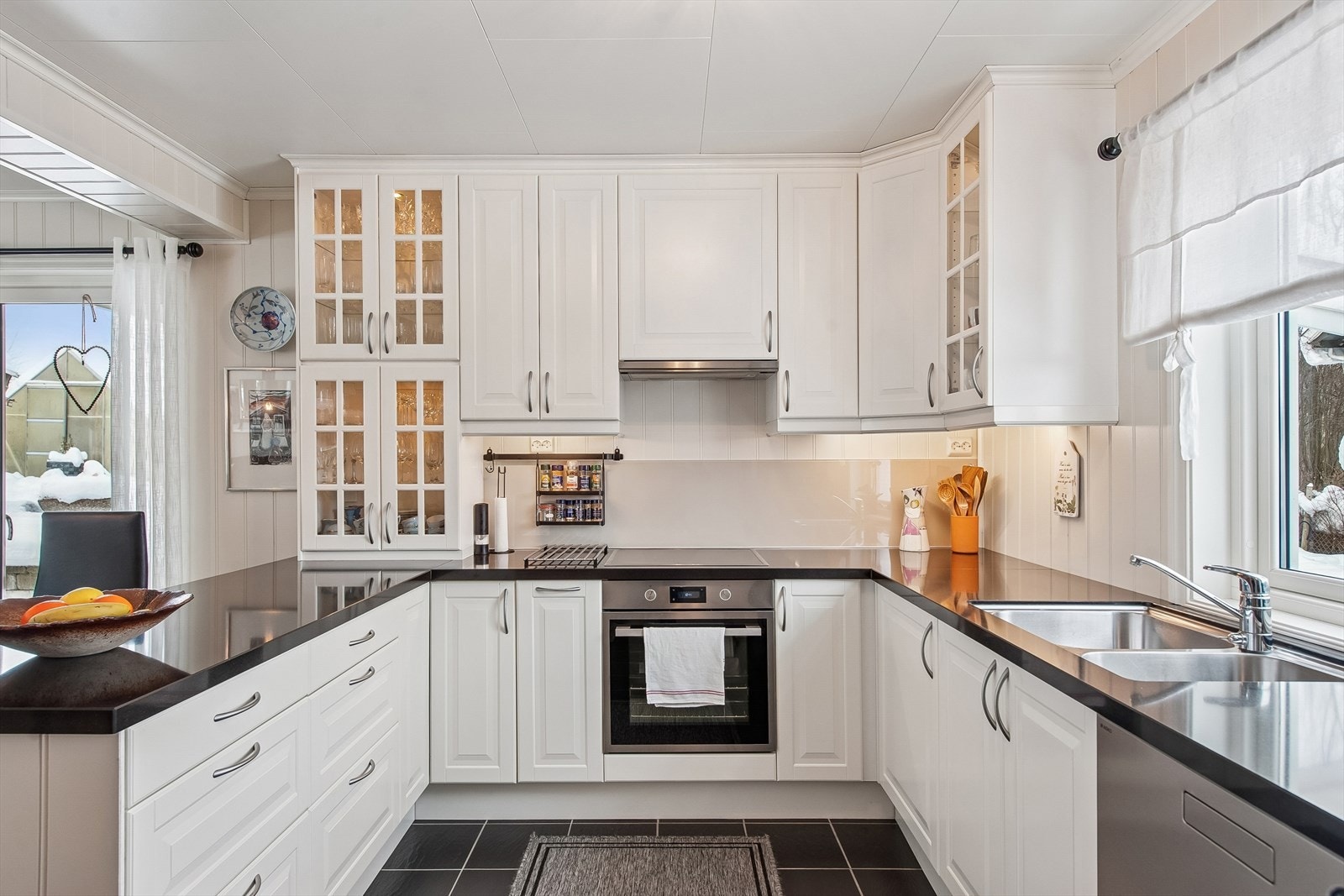 Kjøkkeninnredningen er klassisk hvit med rikelig skap- og benkeplass. Galleribilde