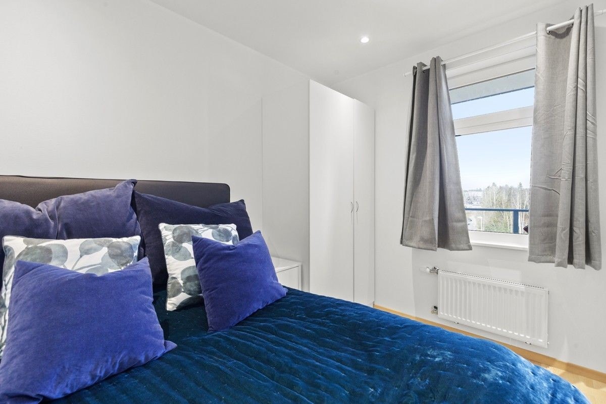 Lyst og romslig soverom med garderobeskap Galleribilde