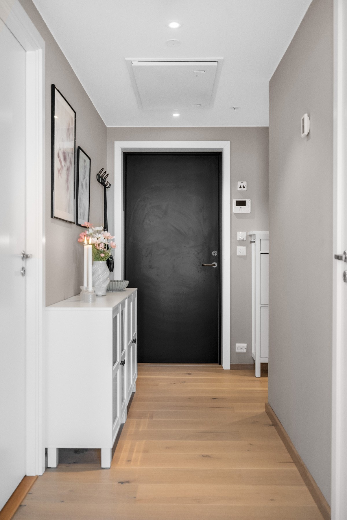 Fra felles oppgang kommer man inn i en romslig entré/gang hvor det er etablert en praktisk skyvedørsgarderobe med speilfronter. Galleribilde