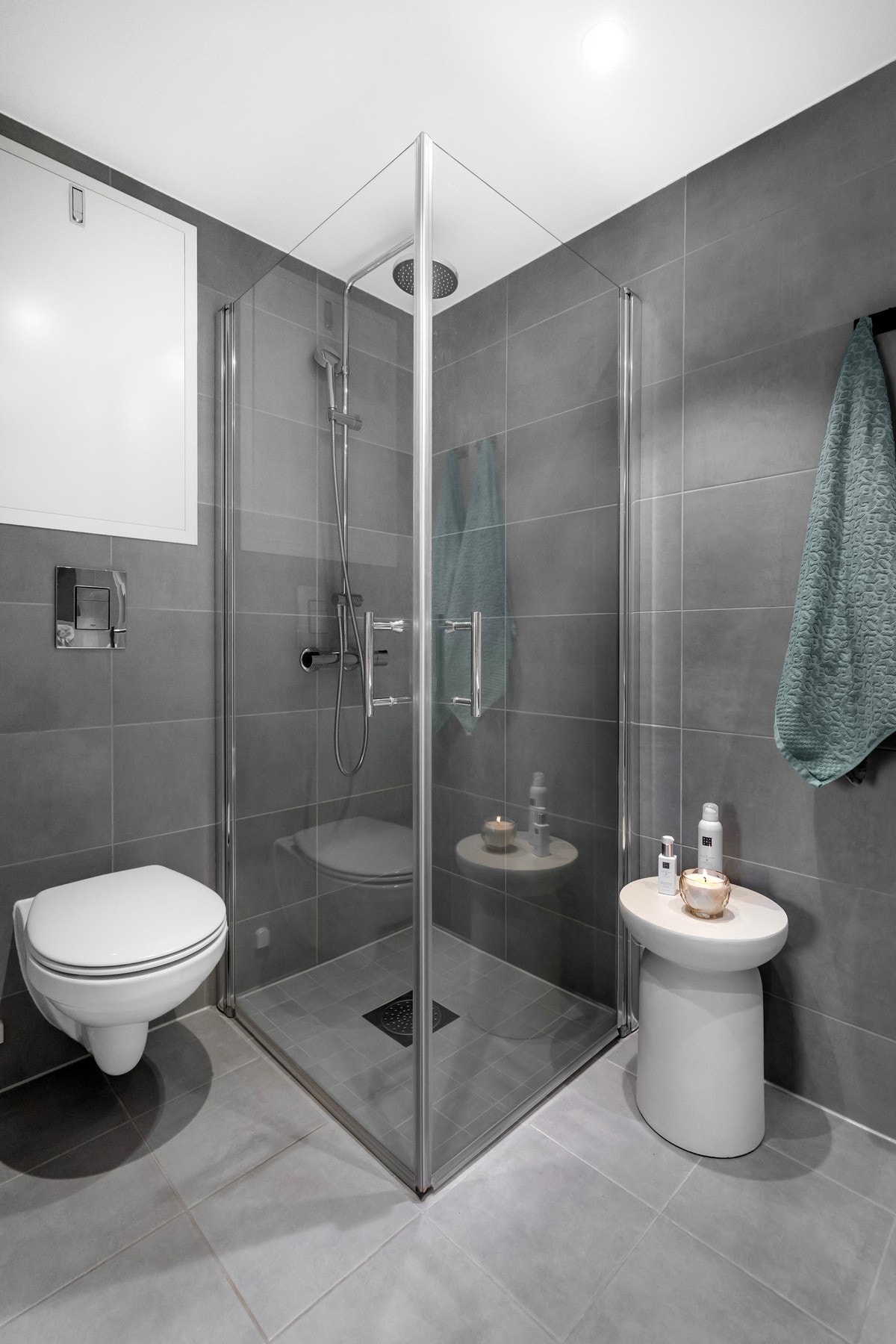 Stilren baderomsinnredning med nedfelt servant, veggmontert toalett og dusj med dusjvegger/hjørneløsning. Galleribilde