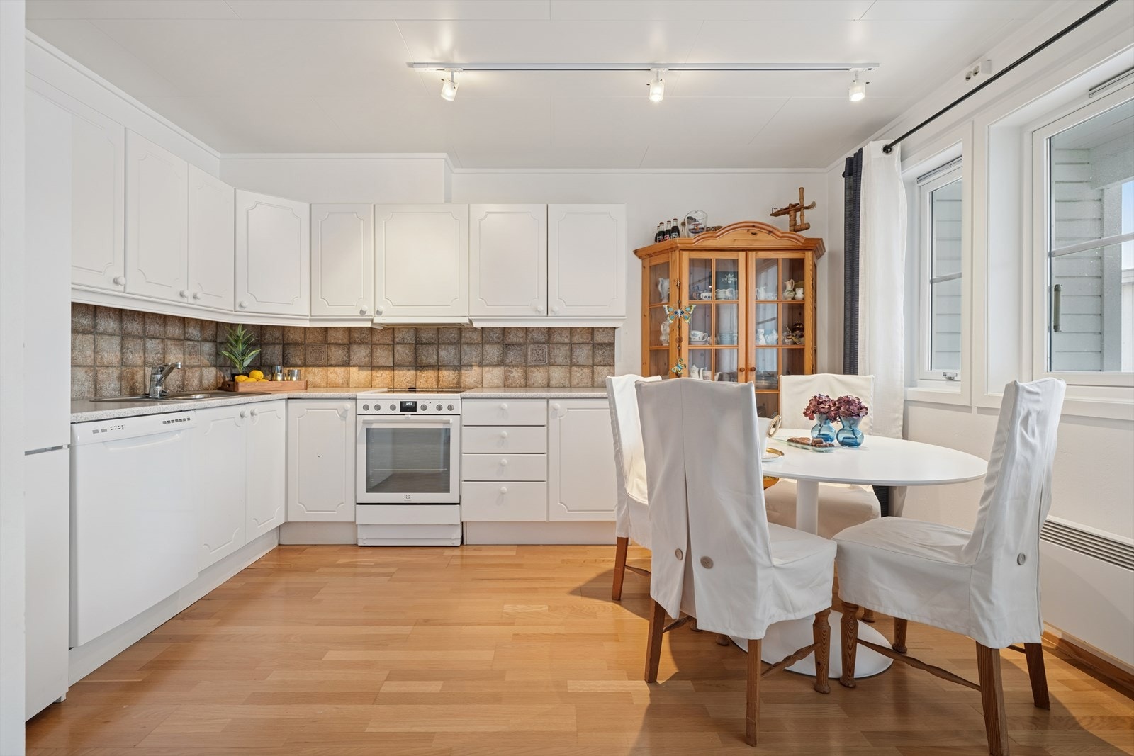 Lyst og tidløst kjøkken med alt en måtte trenge av skap-, skuff- og benkeplass. Galleribilde