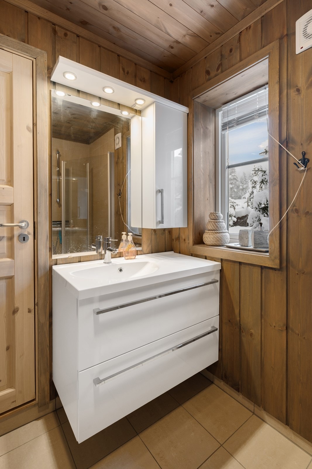 Tidløs innredning med heldekkende servant og tilhørende speil med belysning. Galleribilde