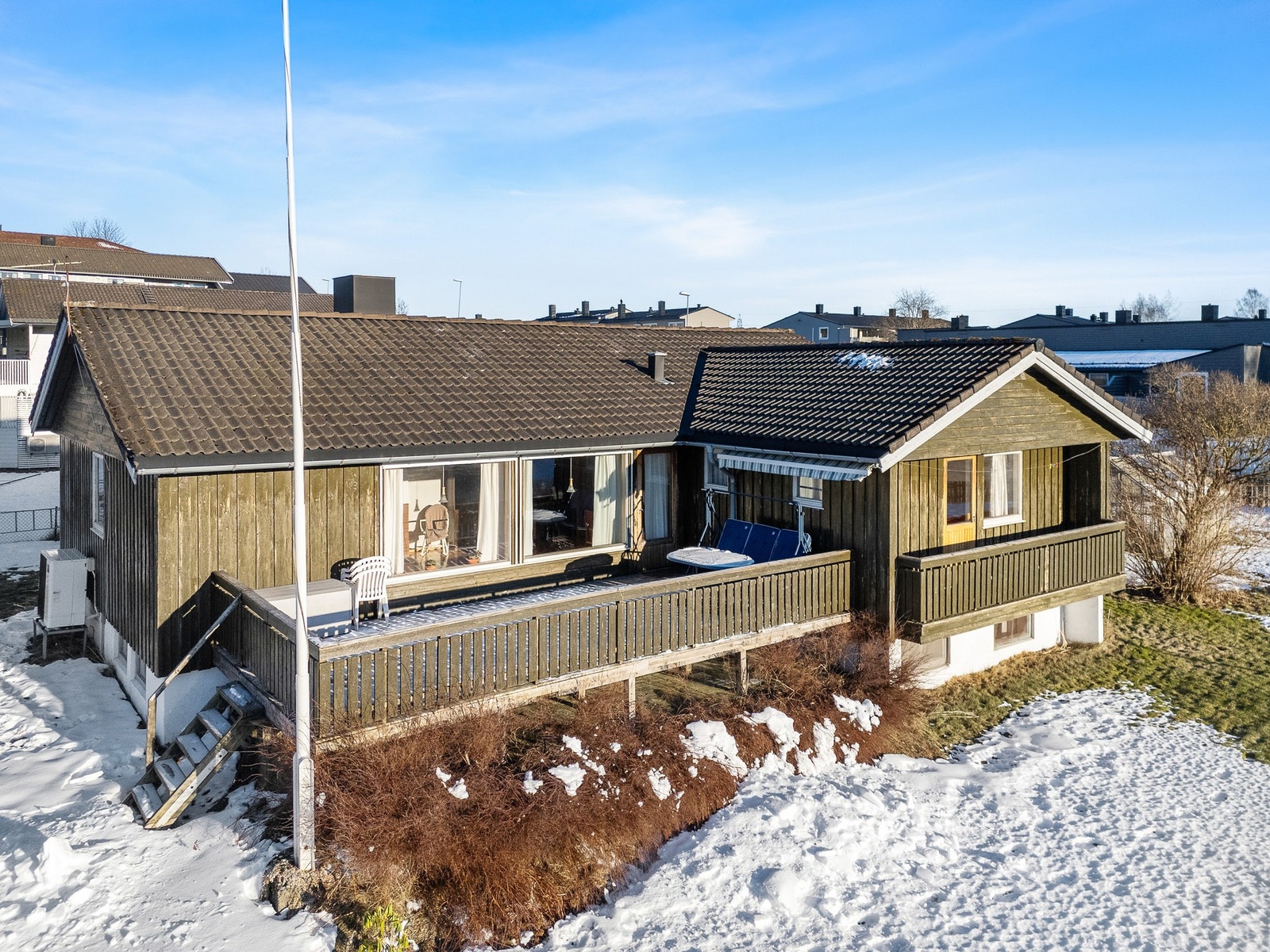Veranda på sørsiden av huset. Bordkledning er av impregnert materiale. Galleribilde