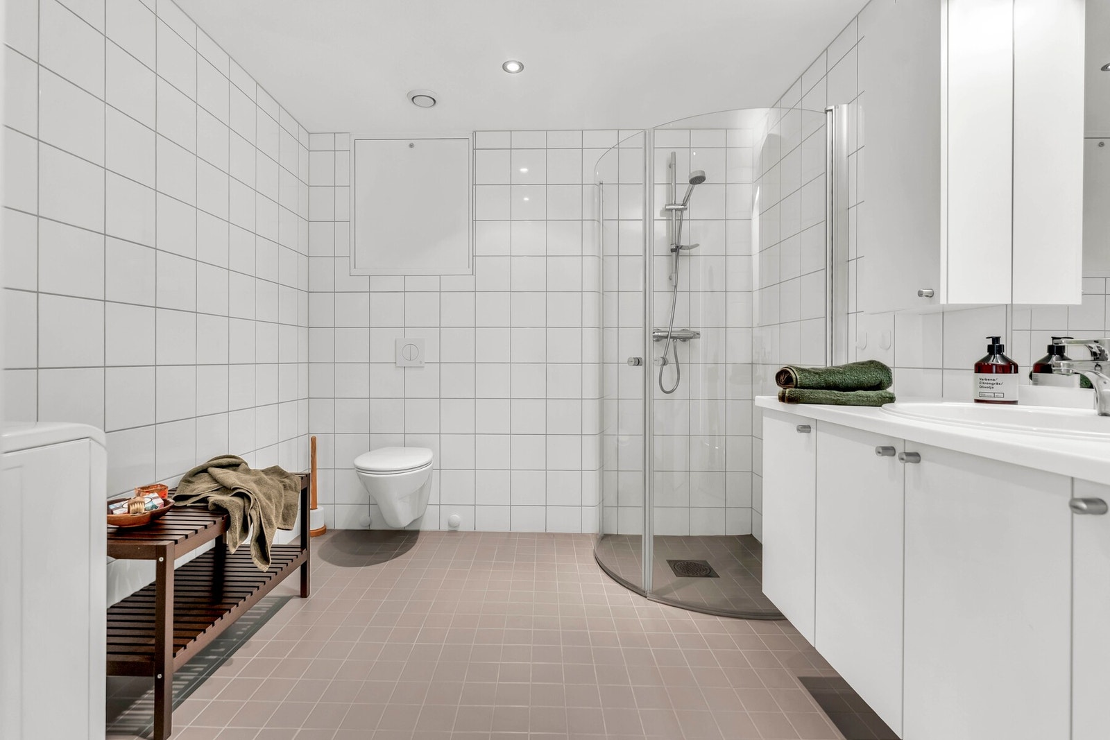 Pent bad med dushjørne, wc og baderomsinnredning. Det er opplegg for vaskemaskin på badet. Galleribilde