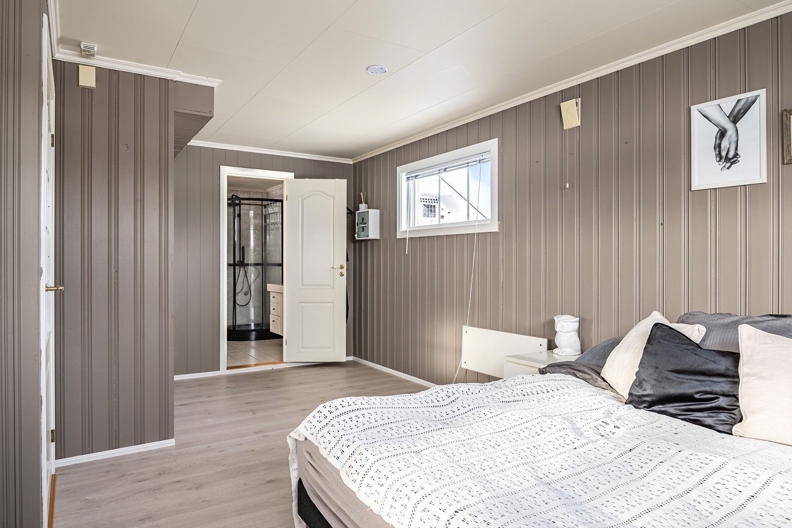 Soverommet i 1. etasje er romslig og har laminatgulv og vegger med panel malt i en tidløs og lun farge. Galleribilde