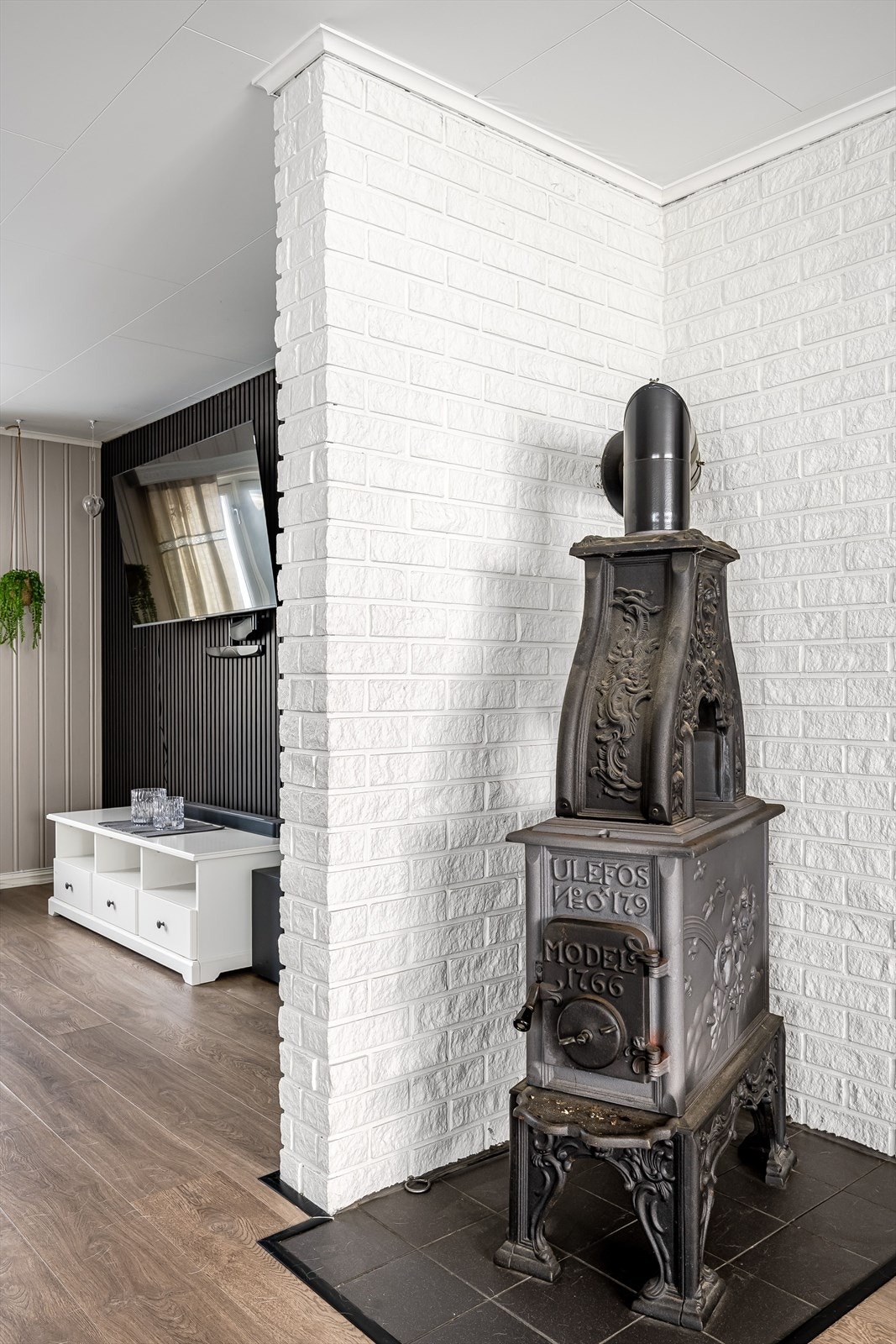 Vedovnen står sentralt og fint plassert i stuen med flislagt felt under og rundt. Galleribilde