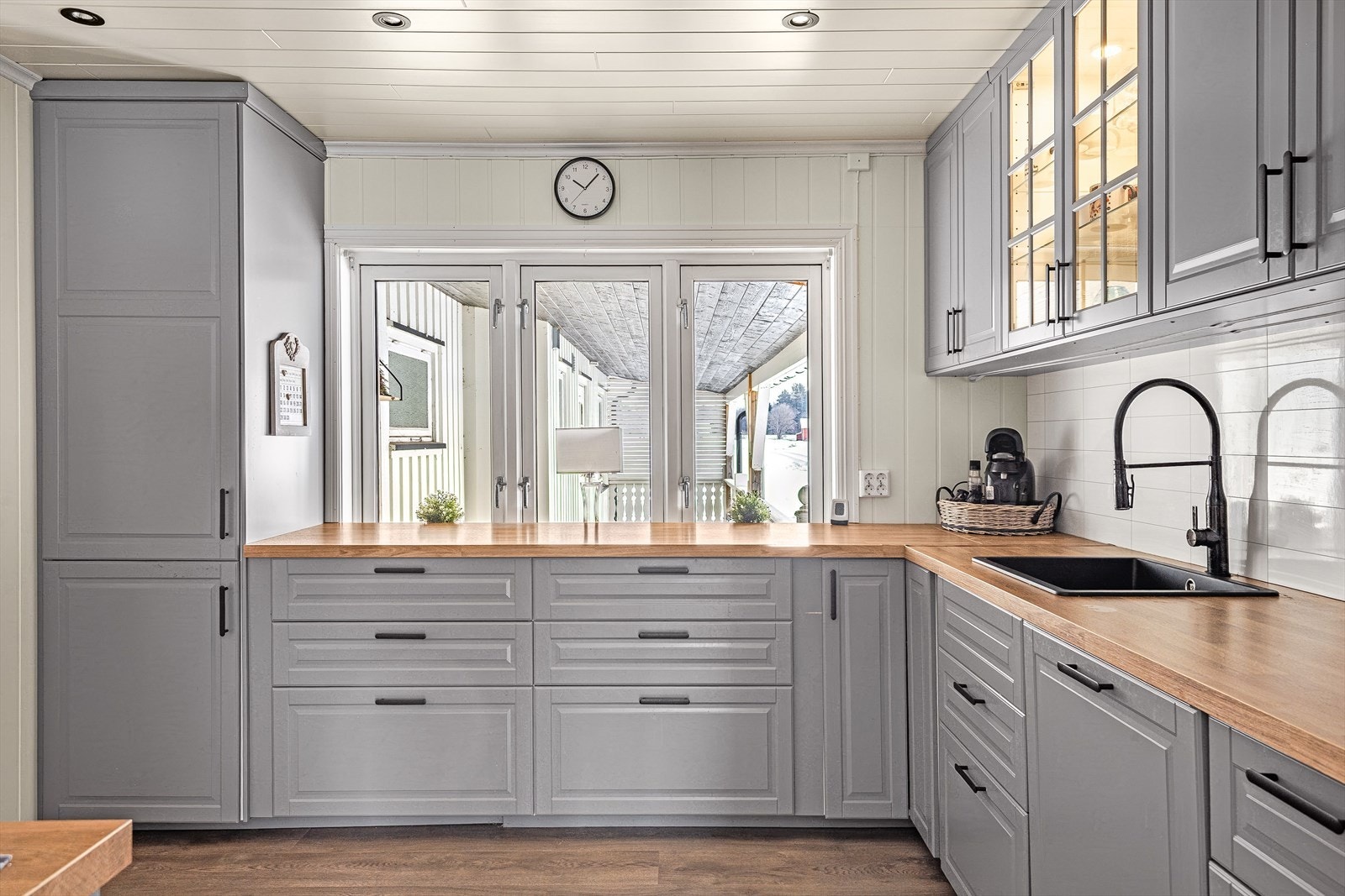 Kjøkkenet har profilerte fronter og laminerte benkeplater med vask i sort kompositt. Galleribilde