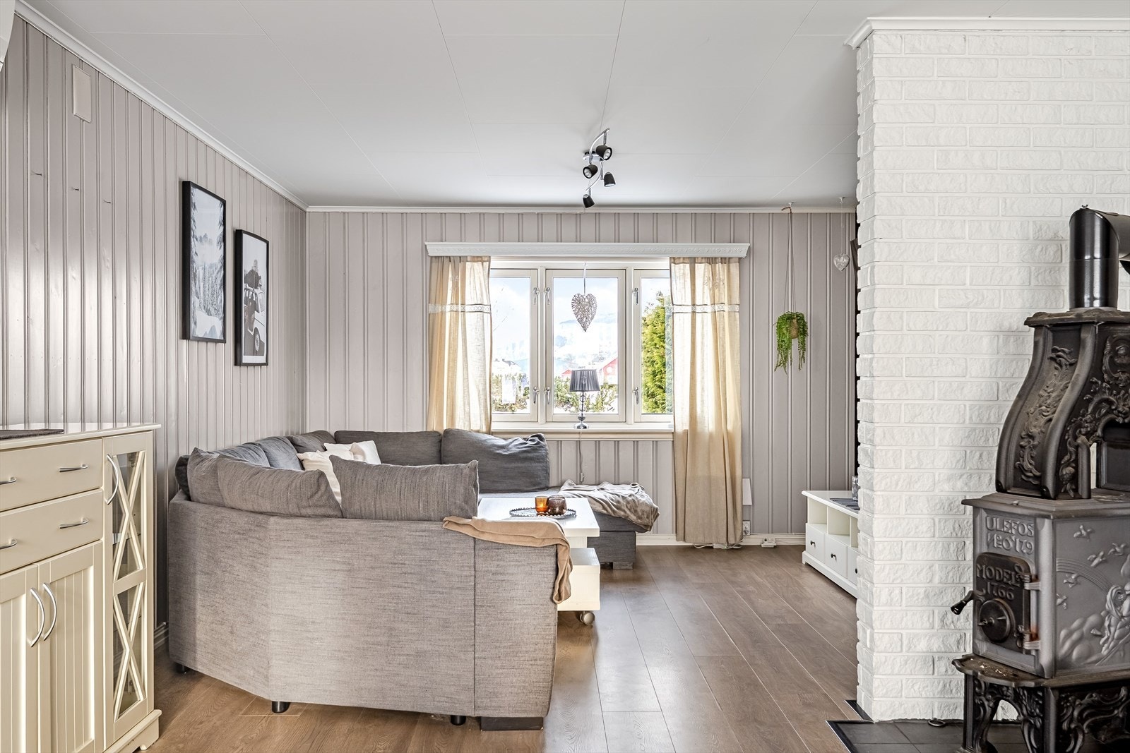 Store vinduer i stuen gir godt med dagslys og utsikt mot hagen. Galleribilde