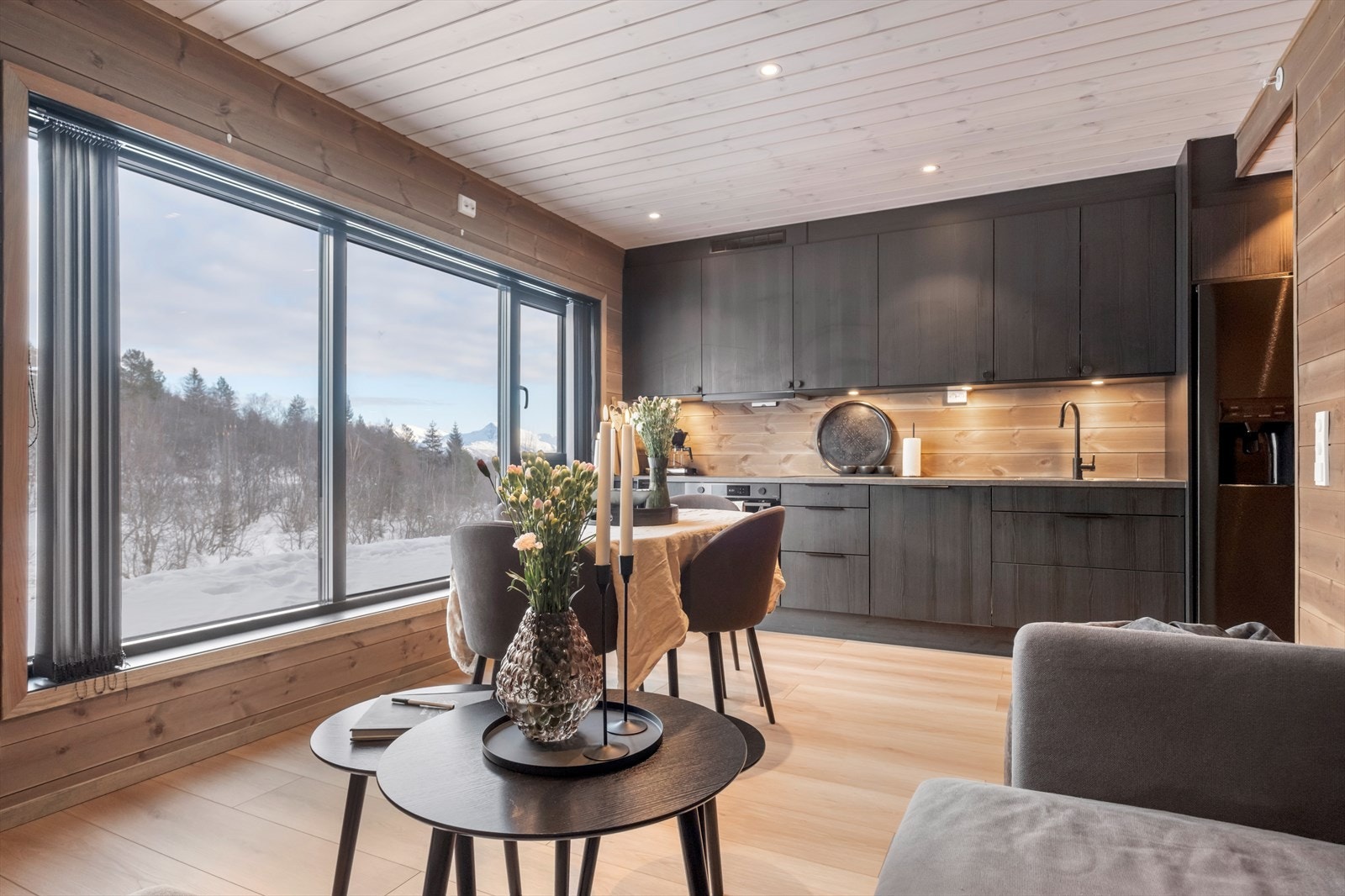 Kjøkkenet har mørke slette fronter og integrerte hvitevarer som gir en stilren arbeidsplass. Galleribilde