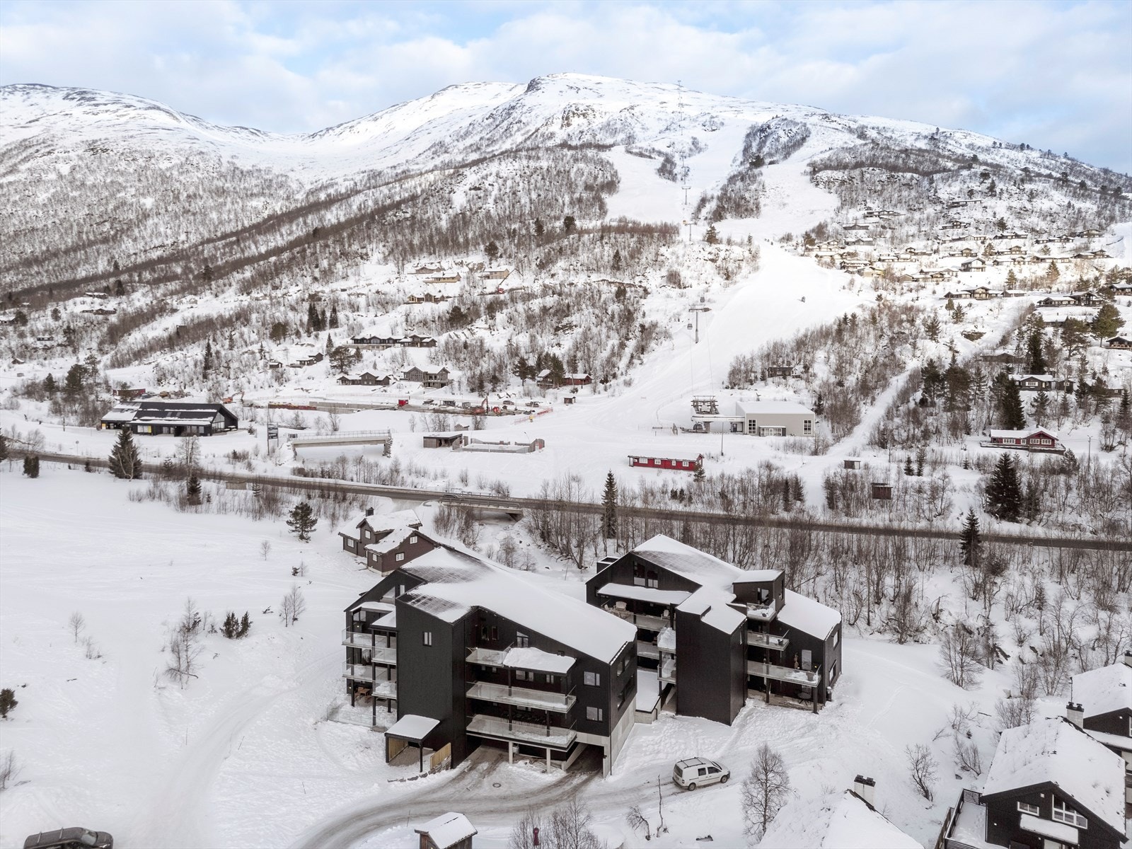 Moderne leilighetsbygg med balkonger som tilbyr utsikt over fjellandskapet. Galleribilde