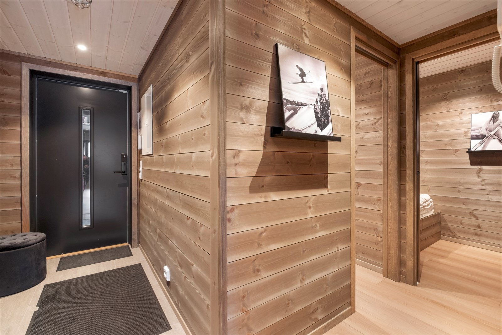 Panelvegger i entréen gir en varm atmosfære, og den sorte ytterdøren er brann- og lydklassifisert. Galleribilde