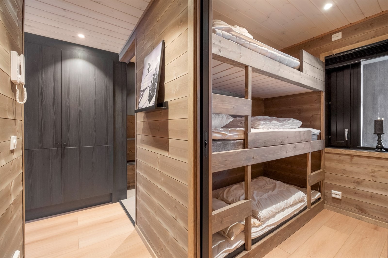 Trevegger og parkettgulv gir et naturlig preg i gangen, med skyvedør til soverommet. Galleribilde