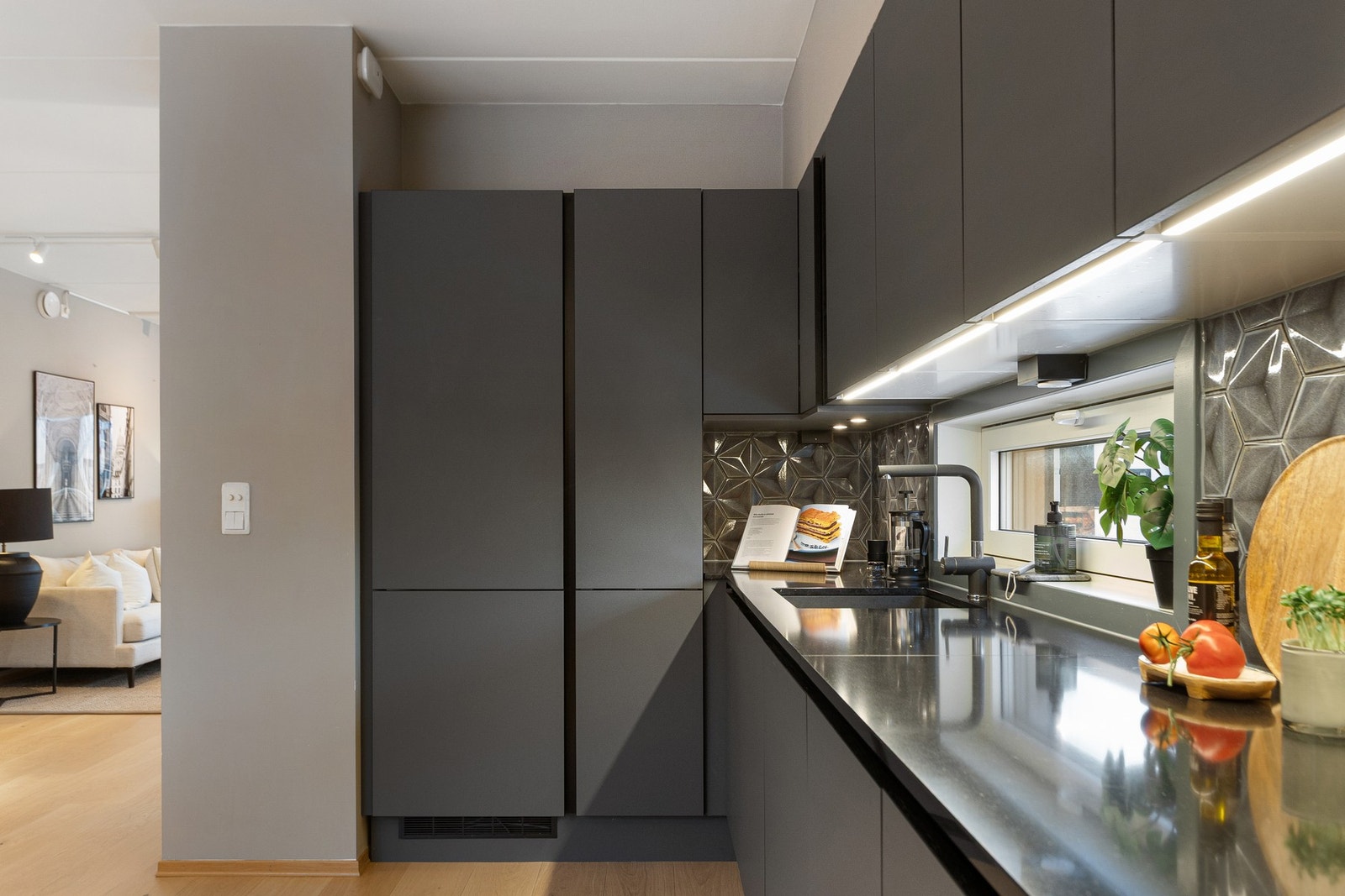 Løsningen byr på gode arbeidsflater, rikelig skapplass og integrert belysning under overskap. Galleribilde