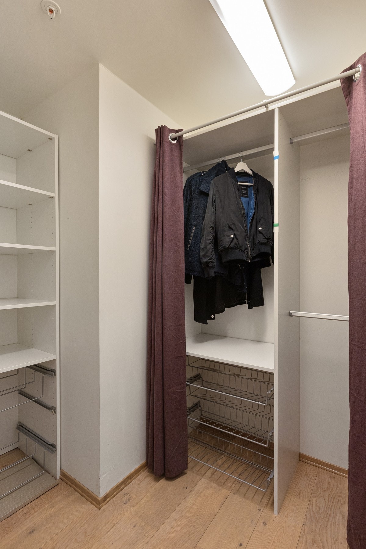 Omkledningsrommet er utstyrt med faste hyller, skuffer og hengeløsninger, som gir god orden og funksjonell oppbevaring av yttertøy, sko og tilbehør. Galleribilde