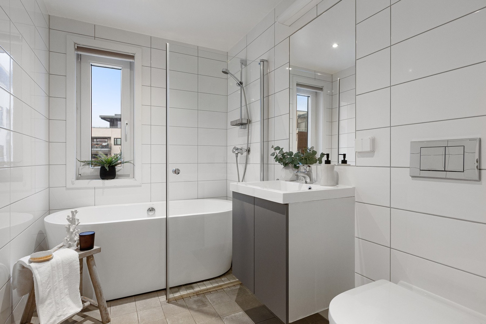 Baderommet er pent og funksjonelt, utført som et dusjbad med tillegg av badekar som gir gode og fleksible bruksmuligheter i hverdagen. Rommet er innredet med baderomsinnredning med nedfelt servant, veggmontert toalett og badekar. Gulvflaten er flislagt, o Galleribilde