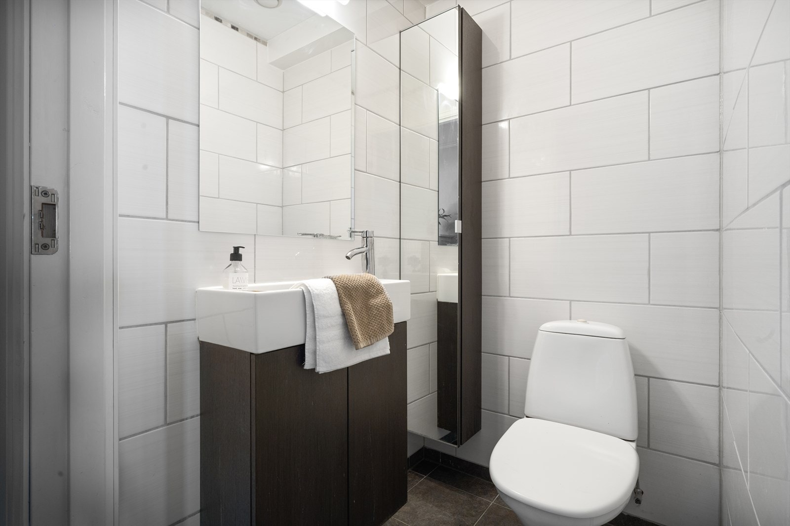 I gangen i 1. etasje finner man et helfliset toalettrom med servant i møbel og toalett. Galleribilde