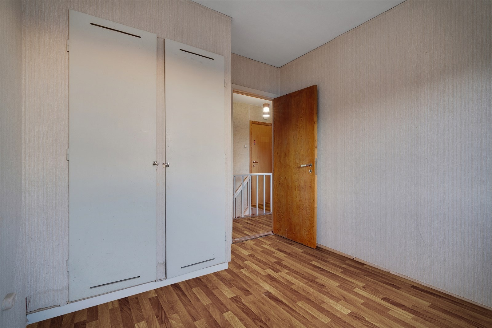 Soverom på 8,3 kvm med laminatgulv og tapet på veggene. Passer fint som hovedsoverom eller ekstra barnerom, med god mulighet for personlig tilpasning Galleribilde