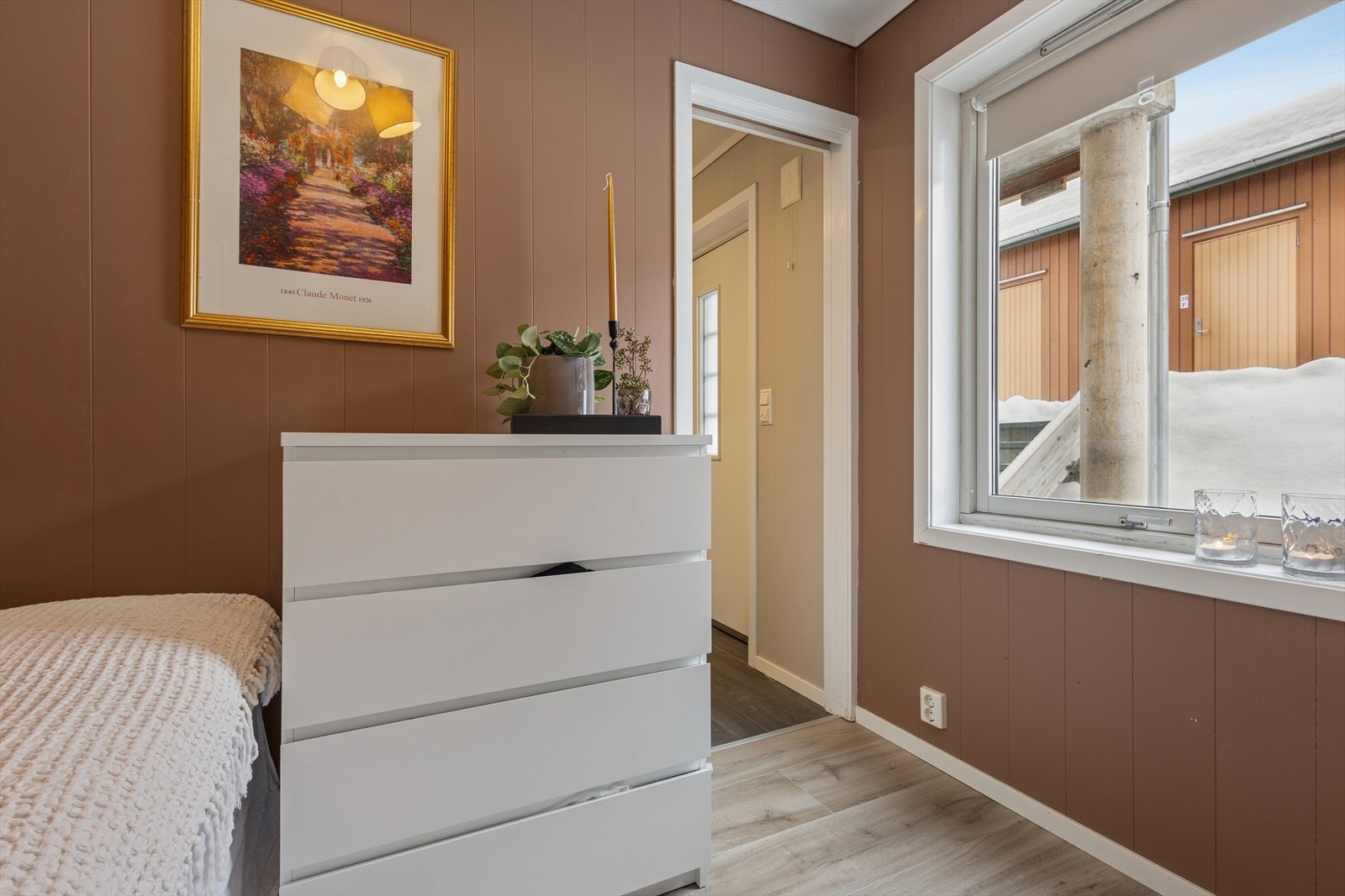 Soverommet har malt panel og laminatgulv, med vindu som gir utsyn til uteområdet. Galleribilde