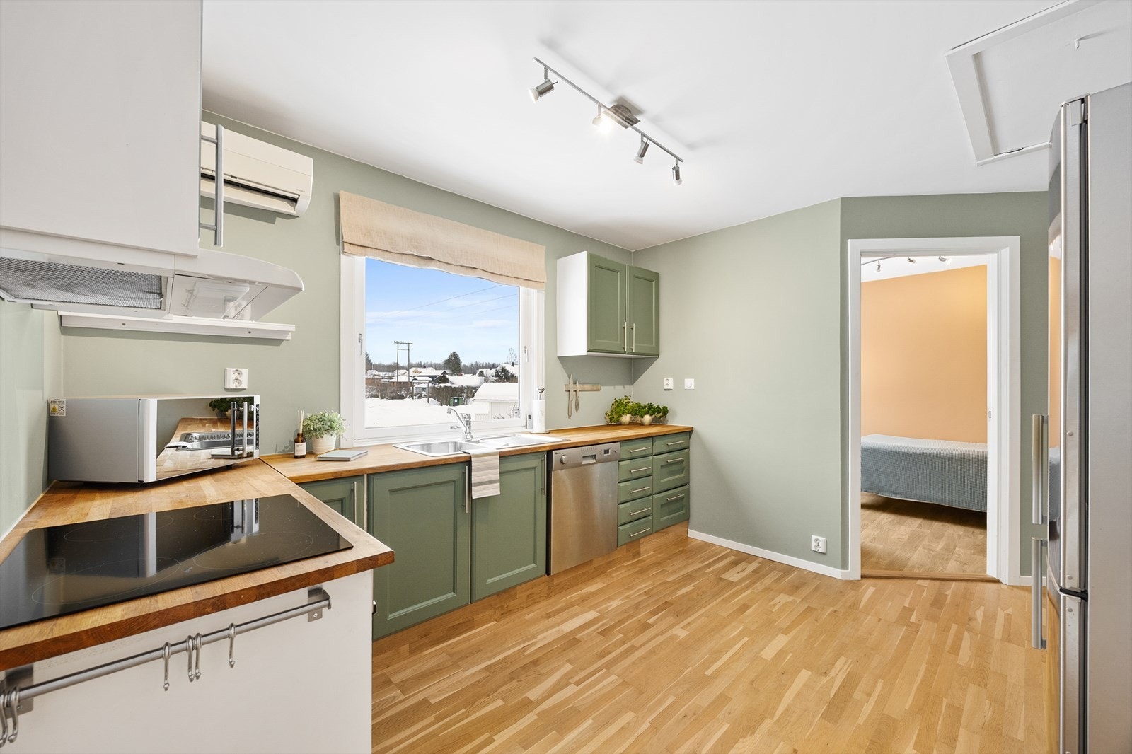 Kjøkkeninnredningen har grønne, profilerte fronter og benkeplate av heltre. Galleribilde