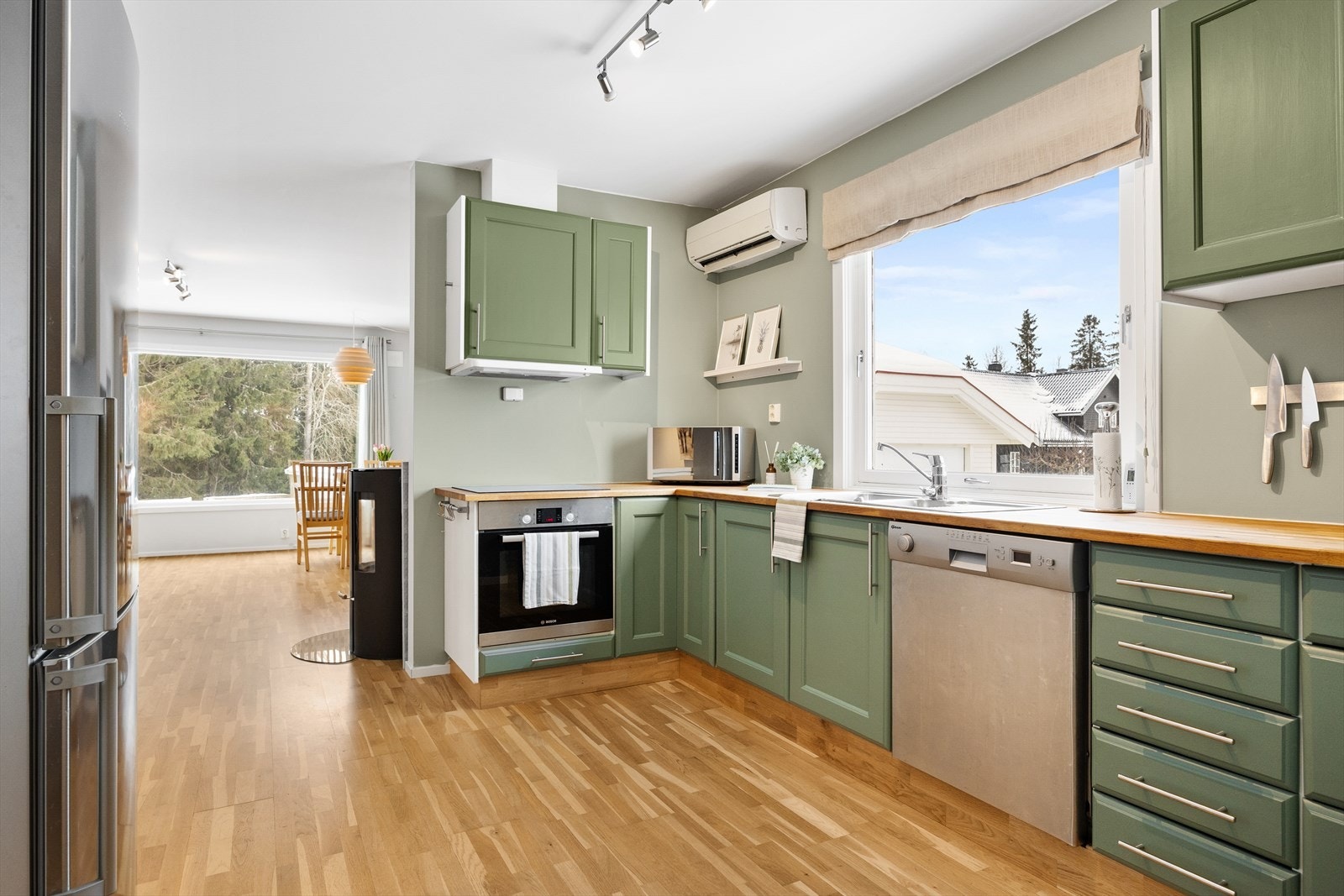 Moderne kjøkken med mye skap- og benkeplass. I rommet er det også montert varmepumpe på vegg. Galleribilde