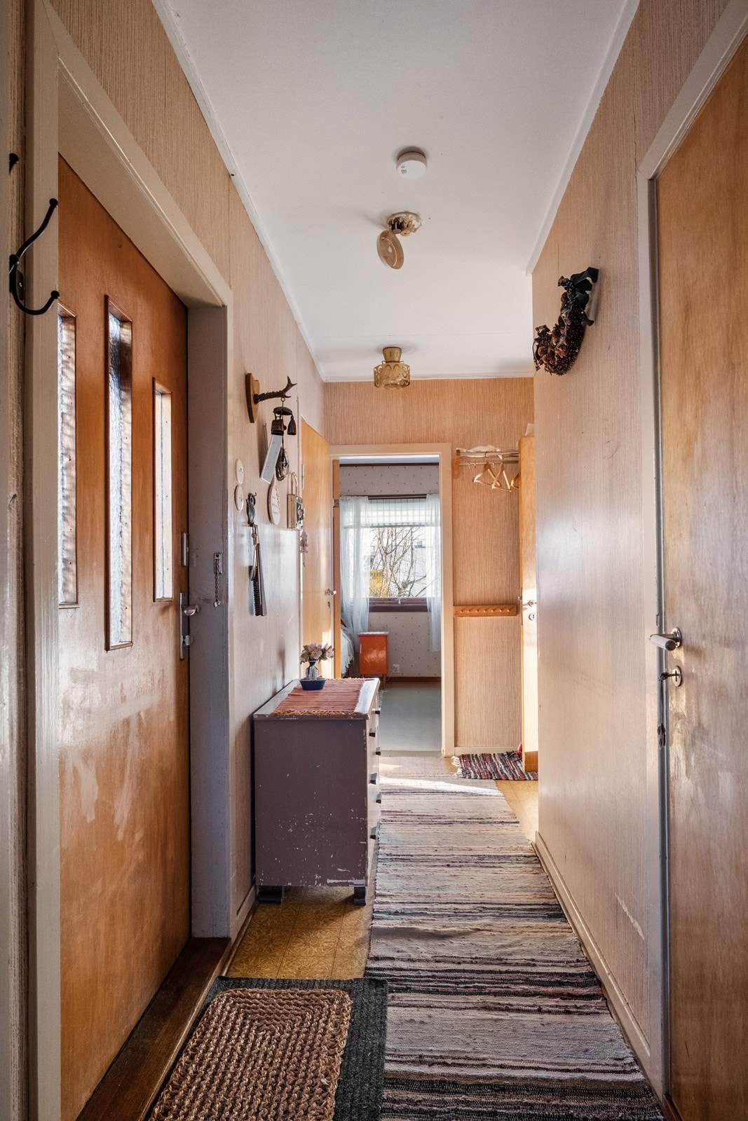 Entrè/ gang, med kjellerdør til høyre, et soverom rett frem og stuen frem og inn til høyre. Galleribilde