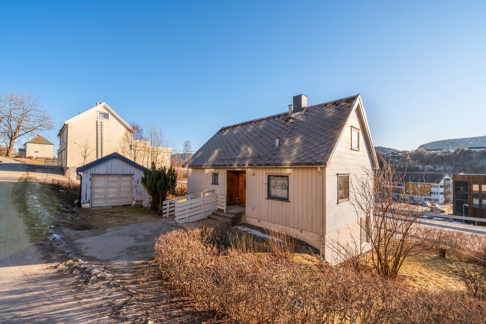 Boligen ligger på en høyde, med gode solforhold. Garasje er oppført i innkjørselen. Galleribilde