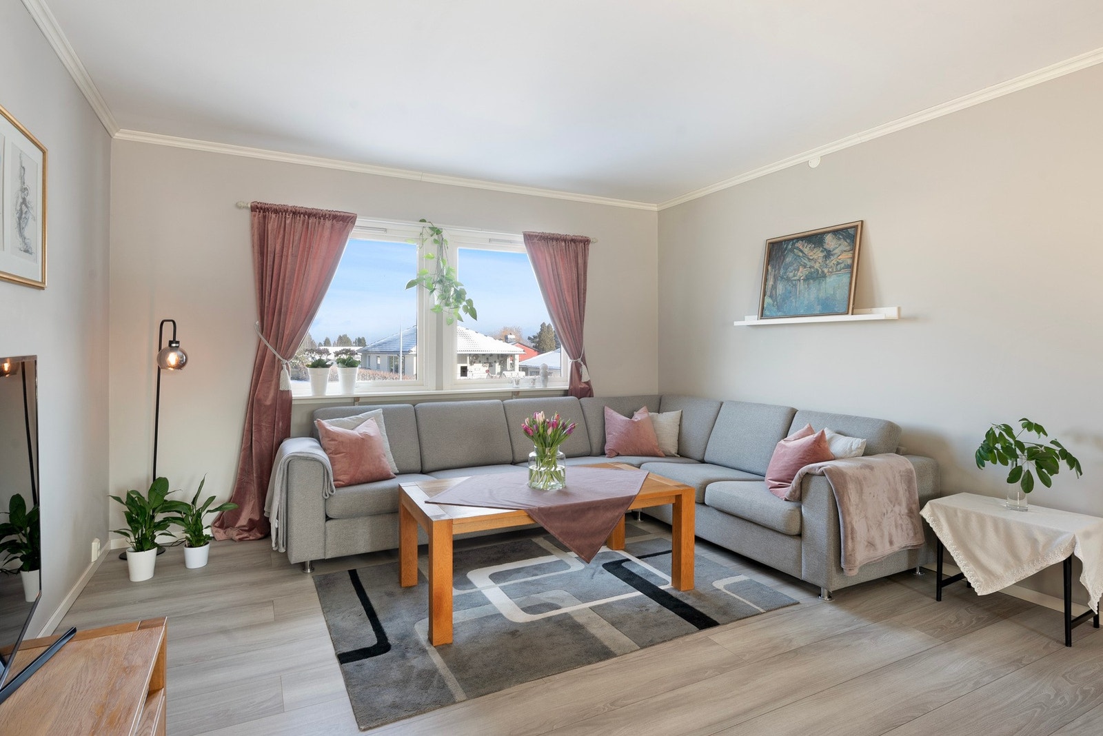 Stuen er romslig og har store vindusflater som slipper inn rikelig med dagslys. Lyse overflater og parkettgulv gir et helhetlig og moderne uttrykk. Galleribilde