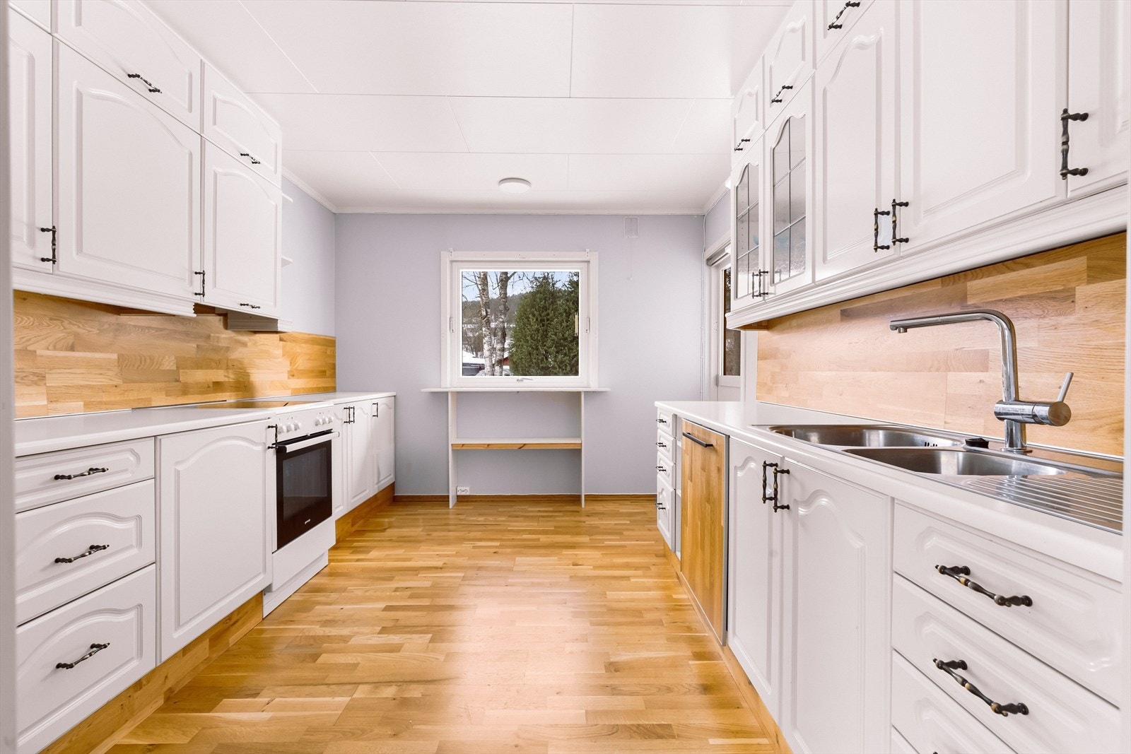 Laminert benkeplate og profilerte fronter gir en funksjonell arbeidsflate på kjøkkenet. Galleribilde