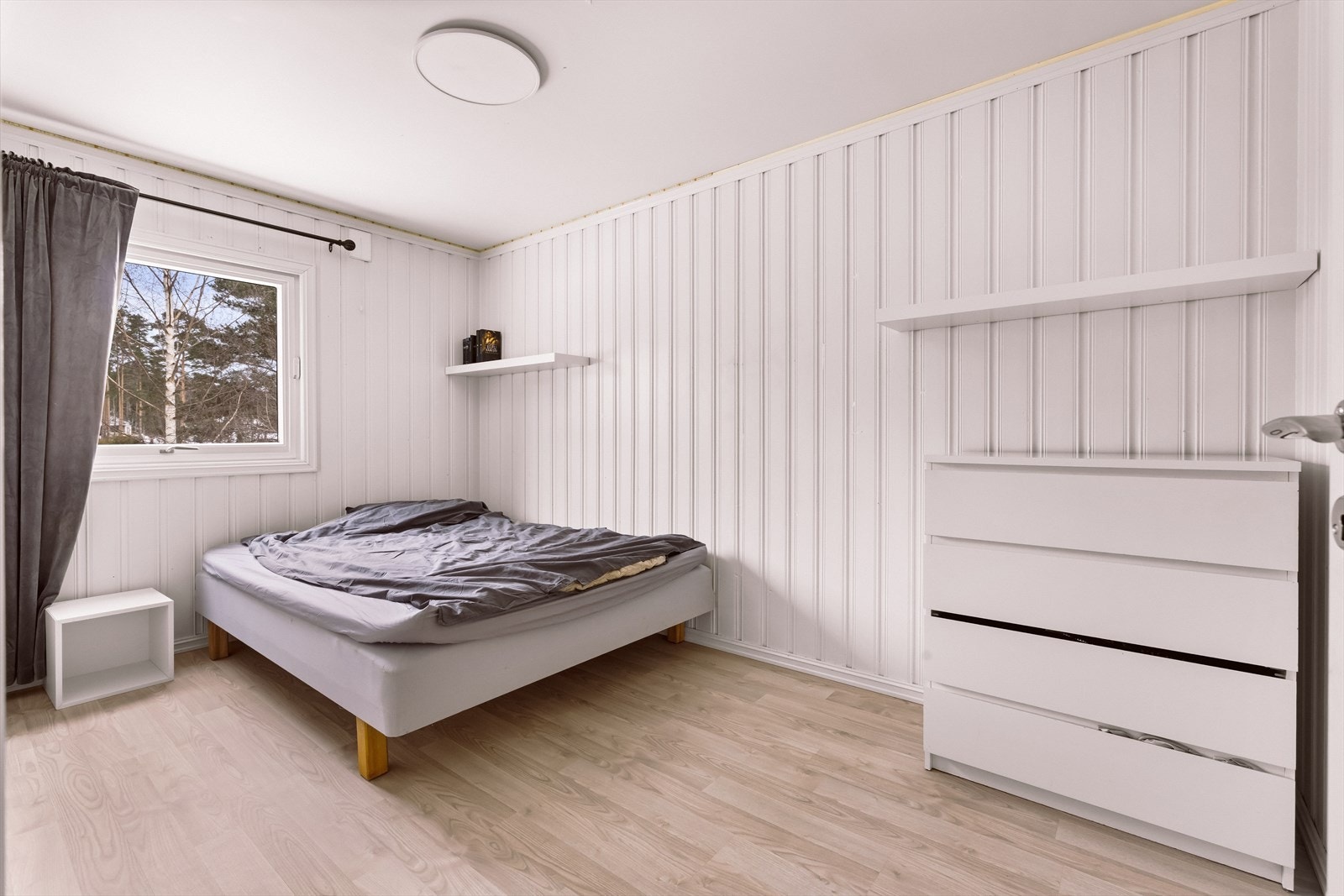 Lyst soverom med parkettgulv og panelte vegger gir et rent uttrykk. Galleribilde