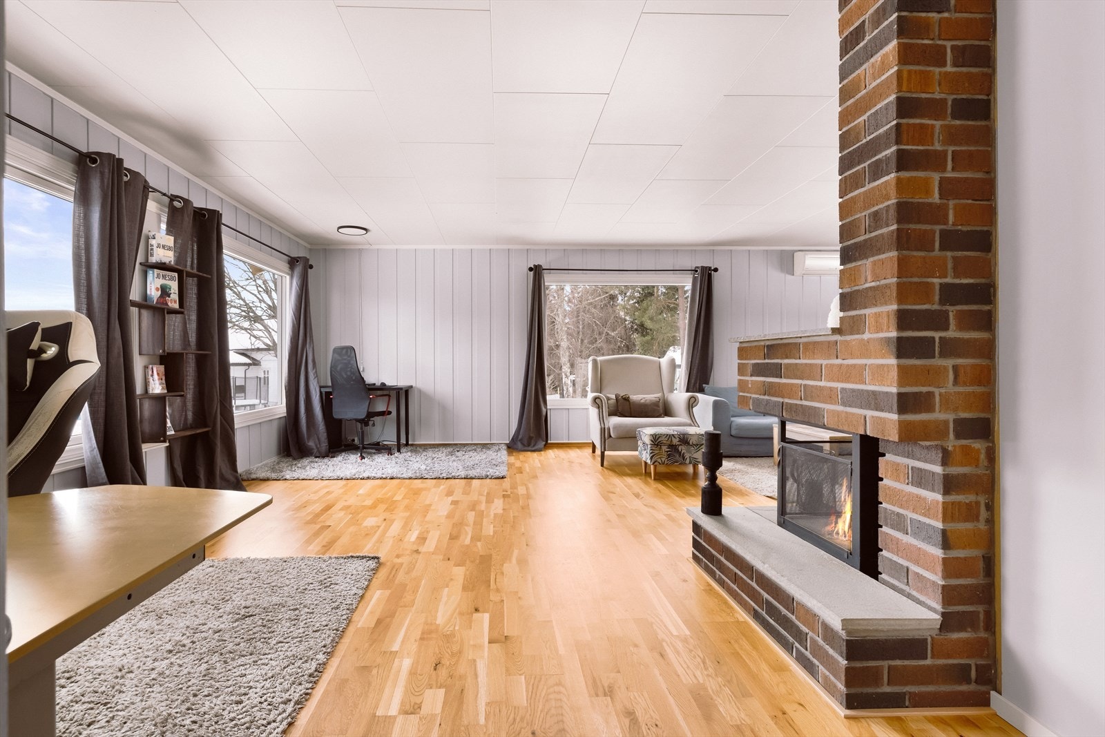 Store vindusflater gir godt lysinnslipp og utsikt mot grøntområder. Vinduer i stuen og soverommet ble skiftet ut i 2022. Galleribilde