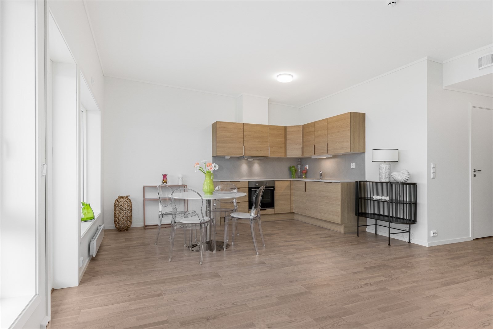 Moderne kjøkkeninnredning med integrerte hvitevarer som komfyr, platetopp og oppvaskmaskin. Vifte over kokesone. Galleribilde