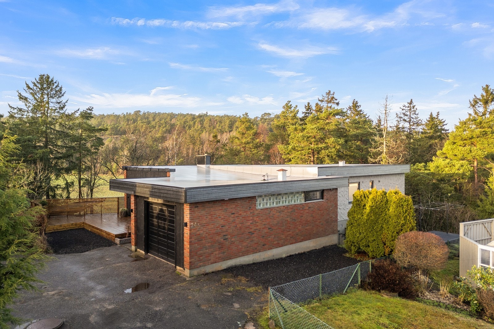 Biloppstillingsplass ved terrasse og ved siden av garasje. Galleribilde