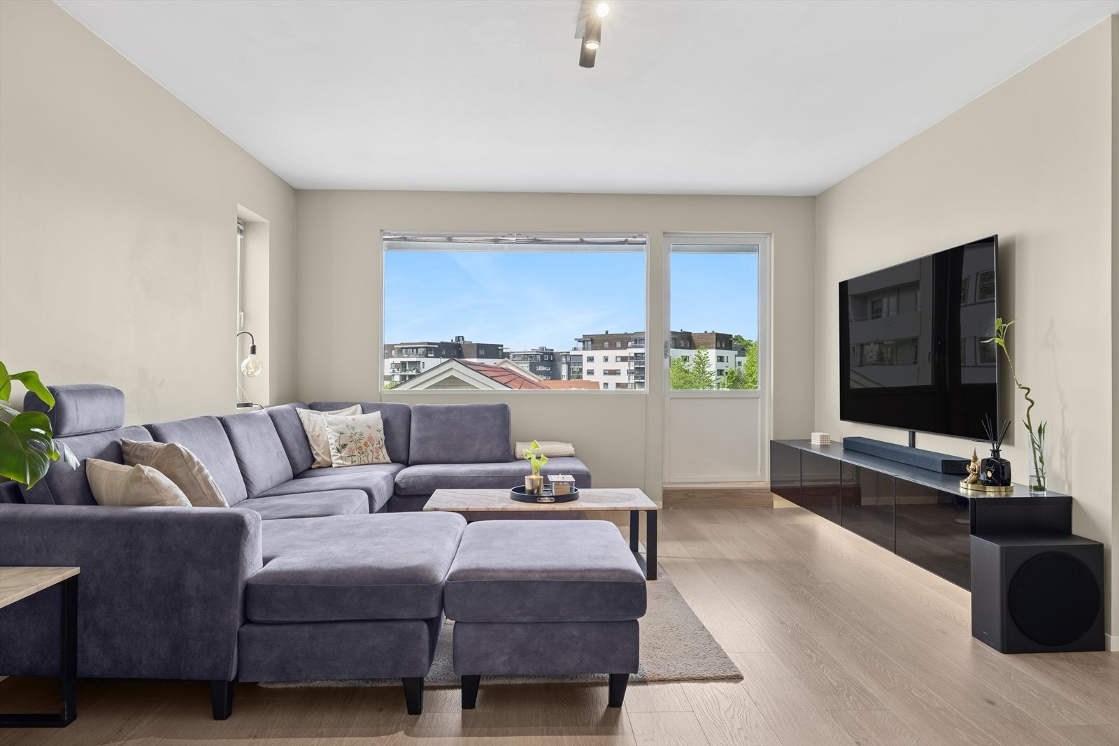 Store vindusflater og delvis glassdør gir rikelig med lys og enkel til balkong - en fin kobling mellom inne og ute Galleribilde