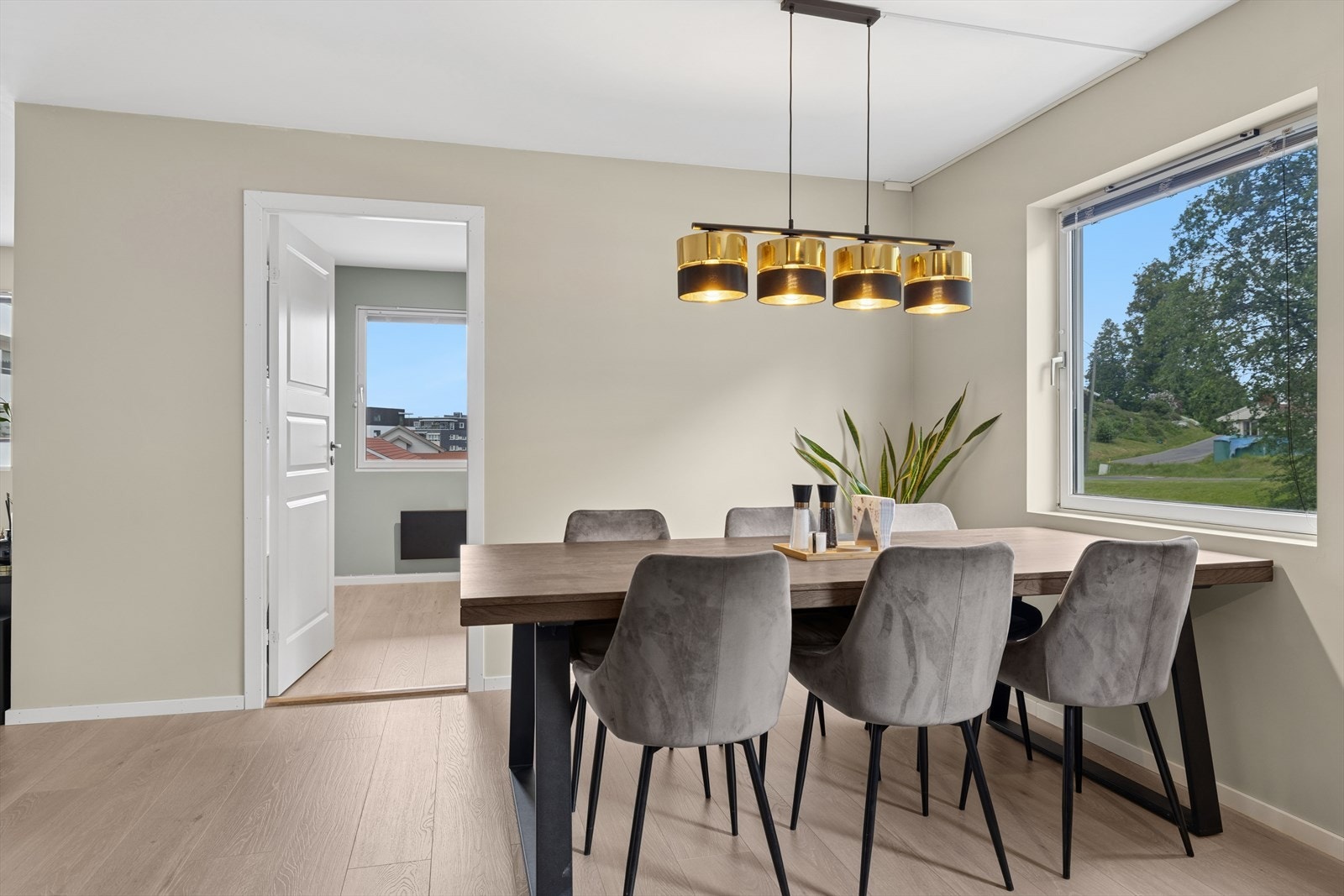 Spisestuen byr på behagelige og moderne fargevalg, og med store vindusflater slippes dagslyset inn i rommet og skaper en lys og innbydende atmosfære Galleribilde