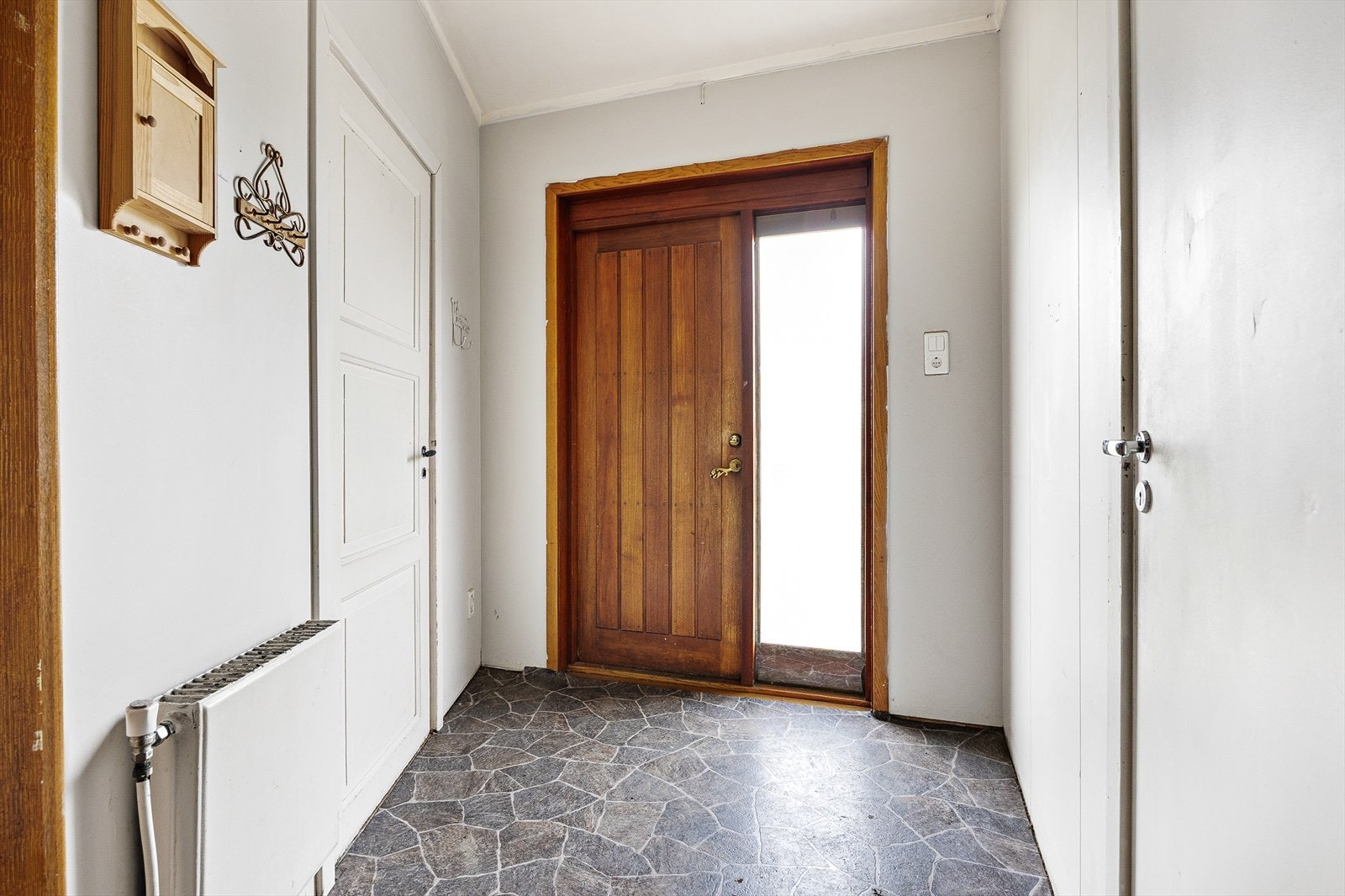 Vi trer inn i boligens første etasje, med hoveddøren i edeltre Galleribilde