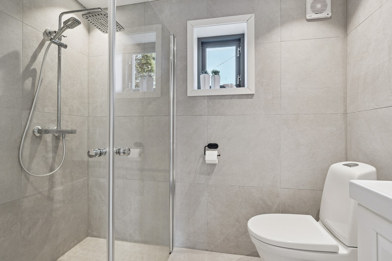 Her finner du servant med underskap, speil, gulvstående toalett og dusjhjørne med glassvegger. Galleribilde