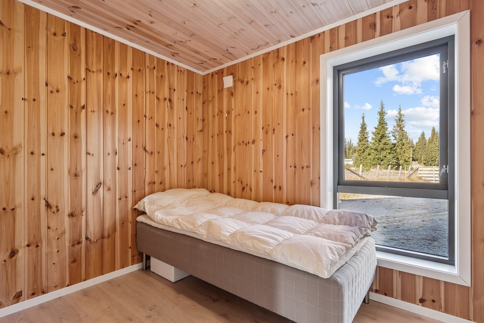 Rommene har lyse overflater, laminatgulv og store vinduer som slipper inn mye naturlig lys. Soverom 2. Galleribilde