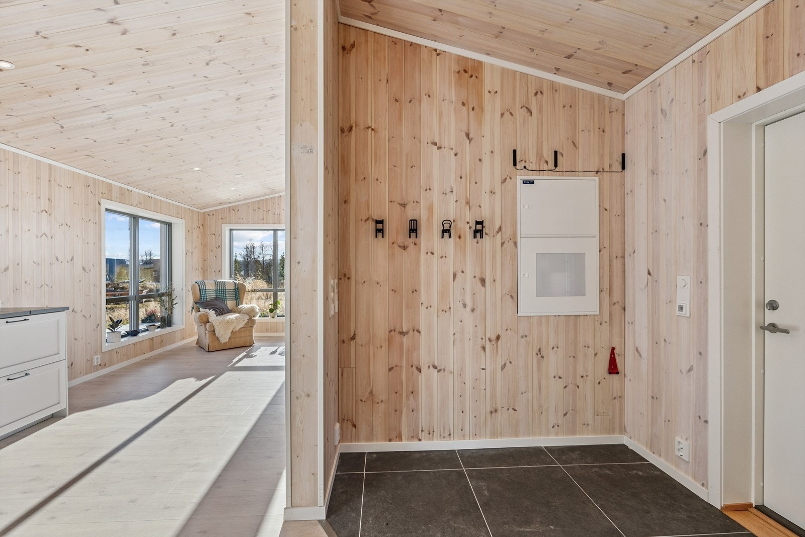 Entreén har direkte forbindelse til stua, og gir en naturlig flyt mellom rommene. Her er det flislagt gulv og plass til yttertøy og sko. Galleribilde