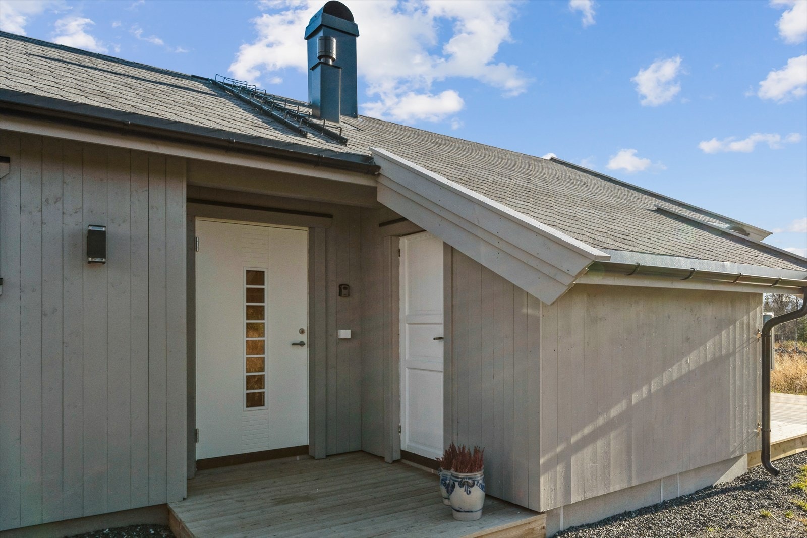 En liten platting foran inngangsdøra ønsker deg velkommen. En romslig utebod ved inngangsdøra er praktisk for å lagre fritidsutstyr, utemøbler eller tørr ved. Galleribilde