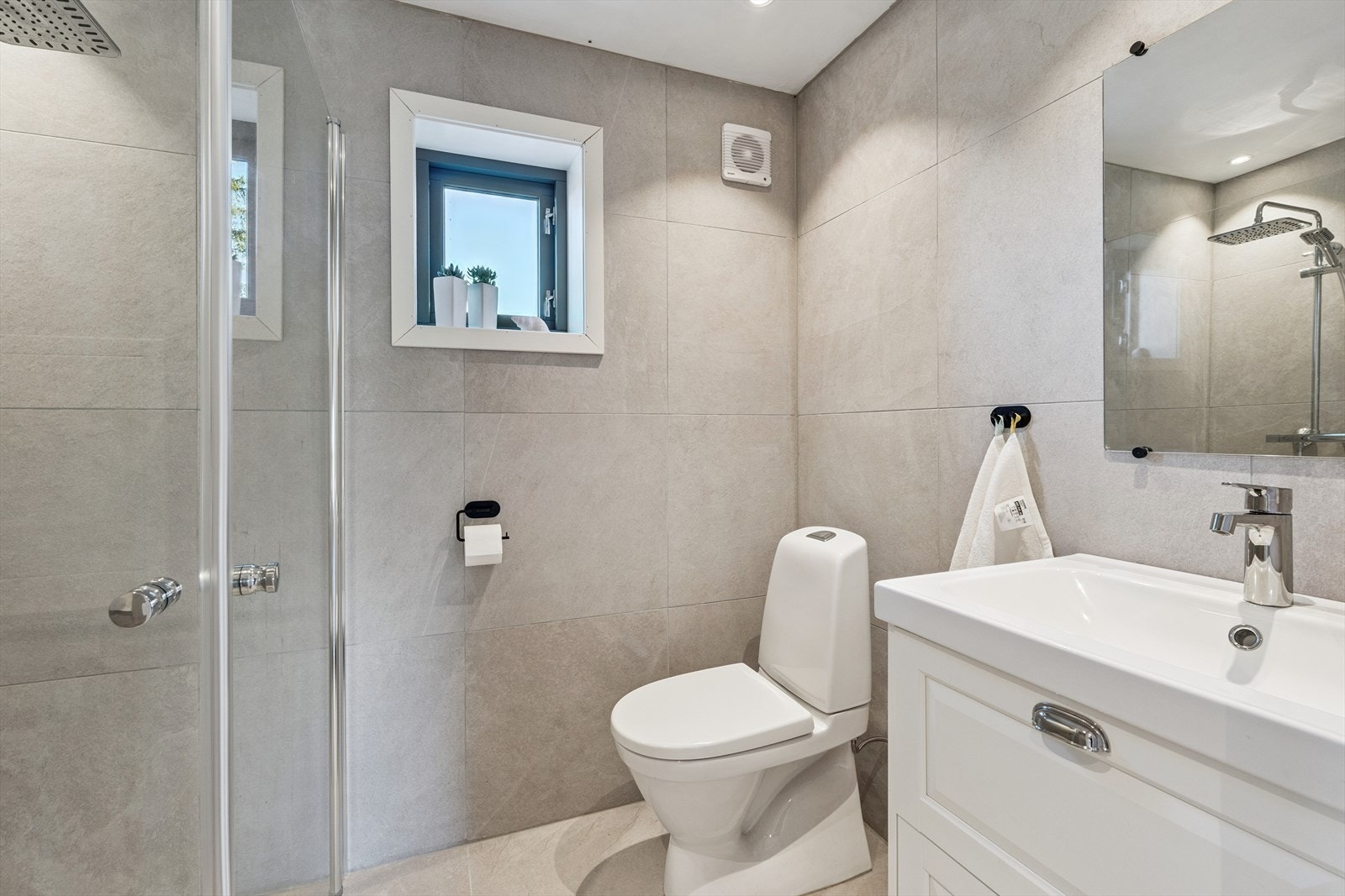 Baderommet har flislagte overflater på både vegger og gulv, med elektriske varmekabler for komfort. Galleribilde