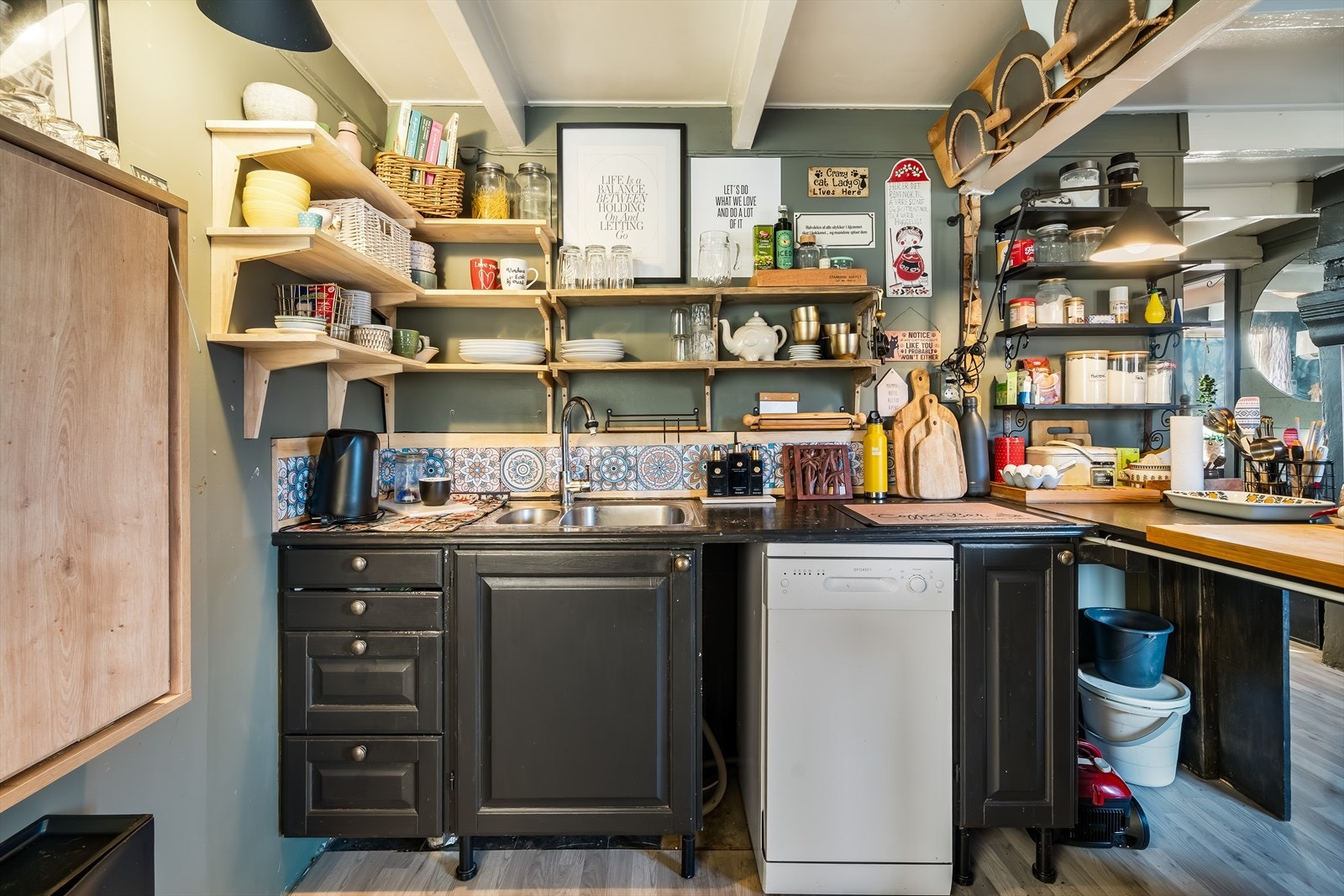 Kjøkken med enkel innredning og avsatt plass til enkeltstående hvitevarer. Galleribilde